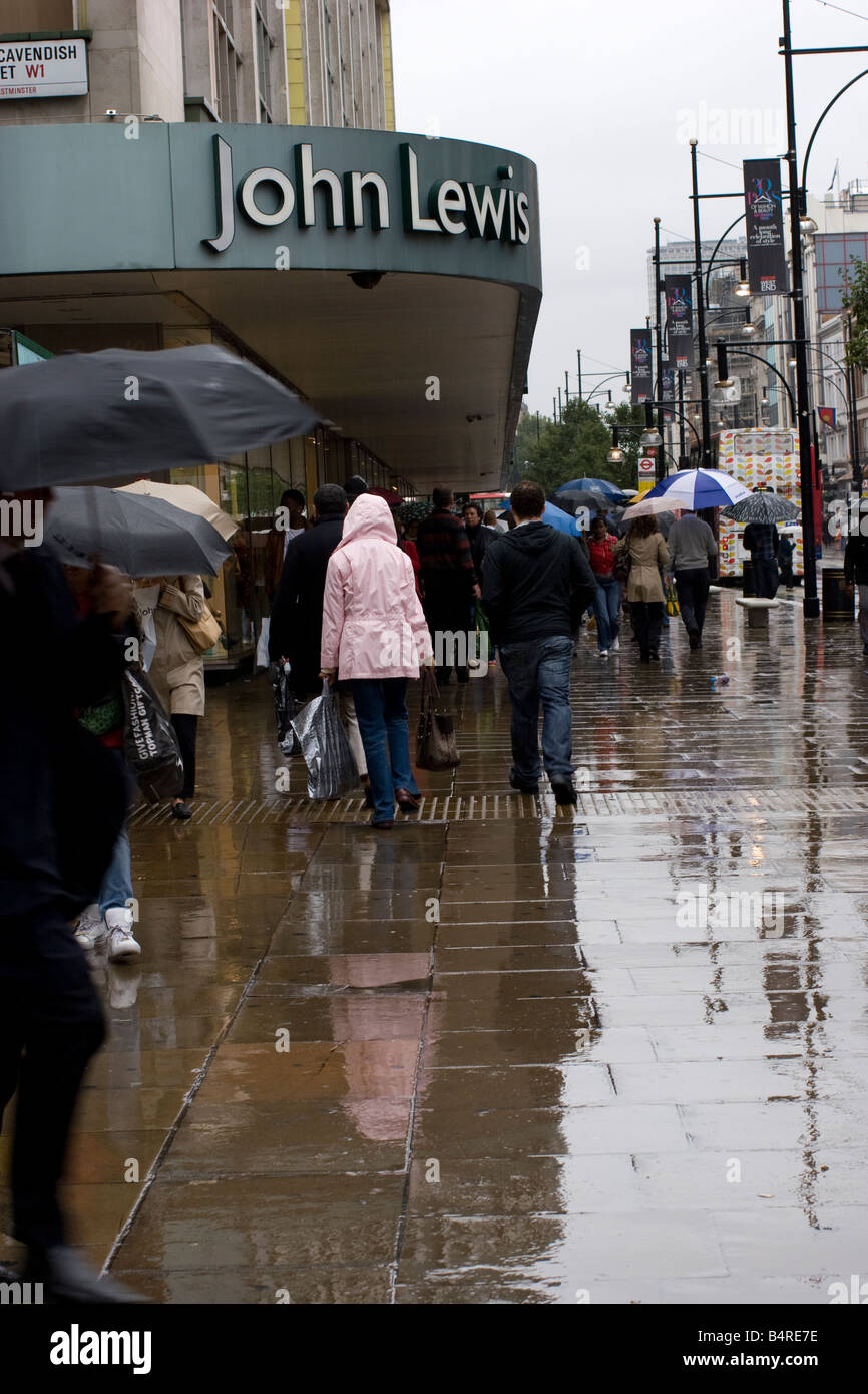 John Lewis oxford street in rain with shoppers and umbrellas during bad