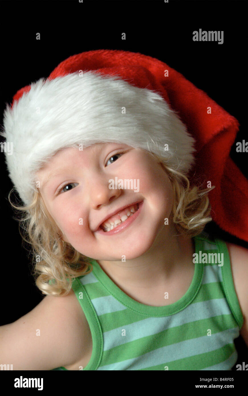 White girl wearing a red christmas hat and green stripy vest. Stock Photo