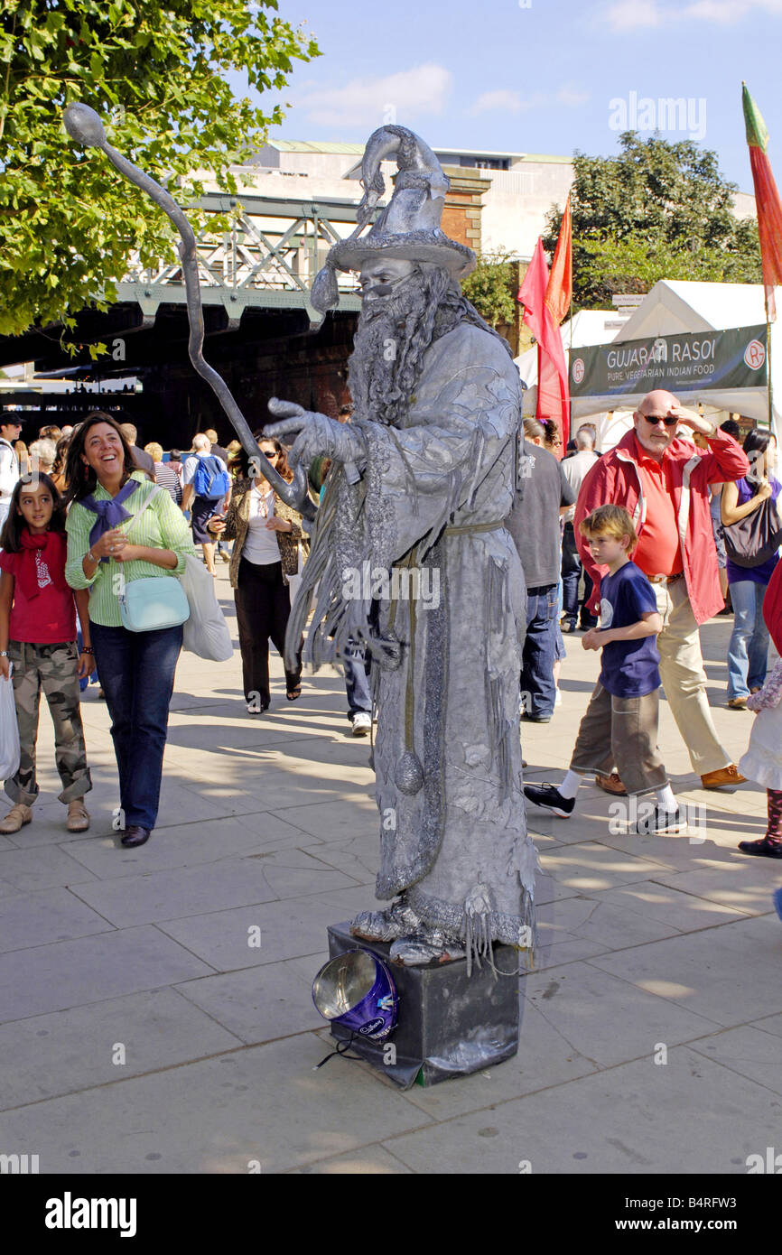 Man dressed in silver as a living statue of Merlin seen on the Thames Embankment during the London Arts Festival Stock Photo