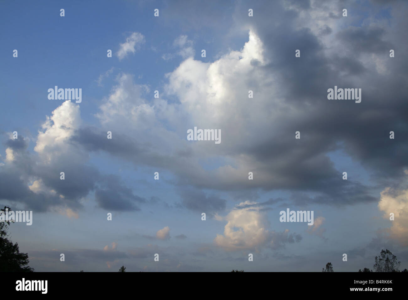 Drifting Cumulus Clouds With Grey Bases Against Blue Sky Stock Photo