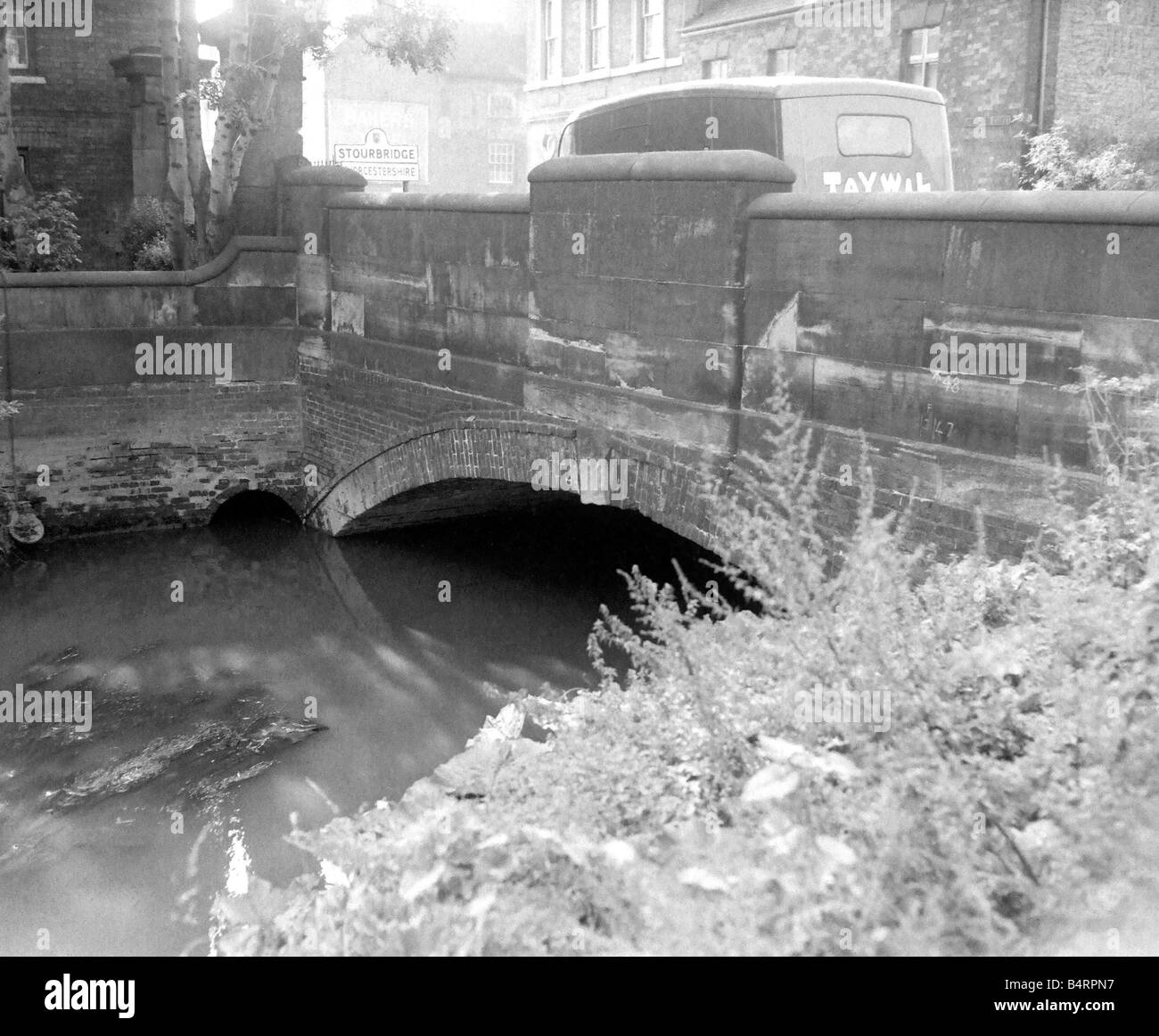 Driftwood floating on the river Vans crossing over the bridge on their way towards Stourbridge town centre 1958 Stock Photo