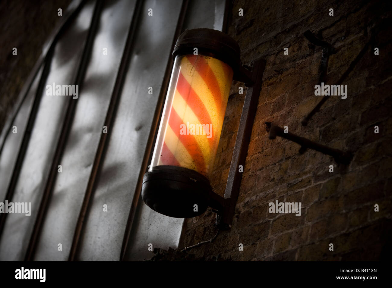 A traditional red and white barbers pole sign outside a in