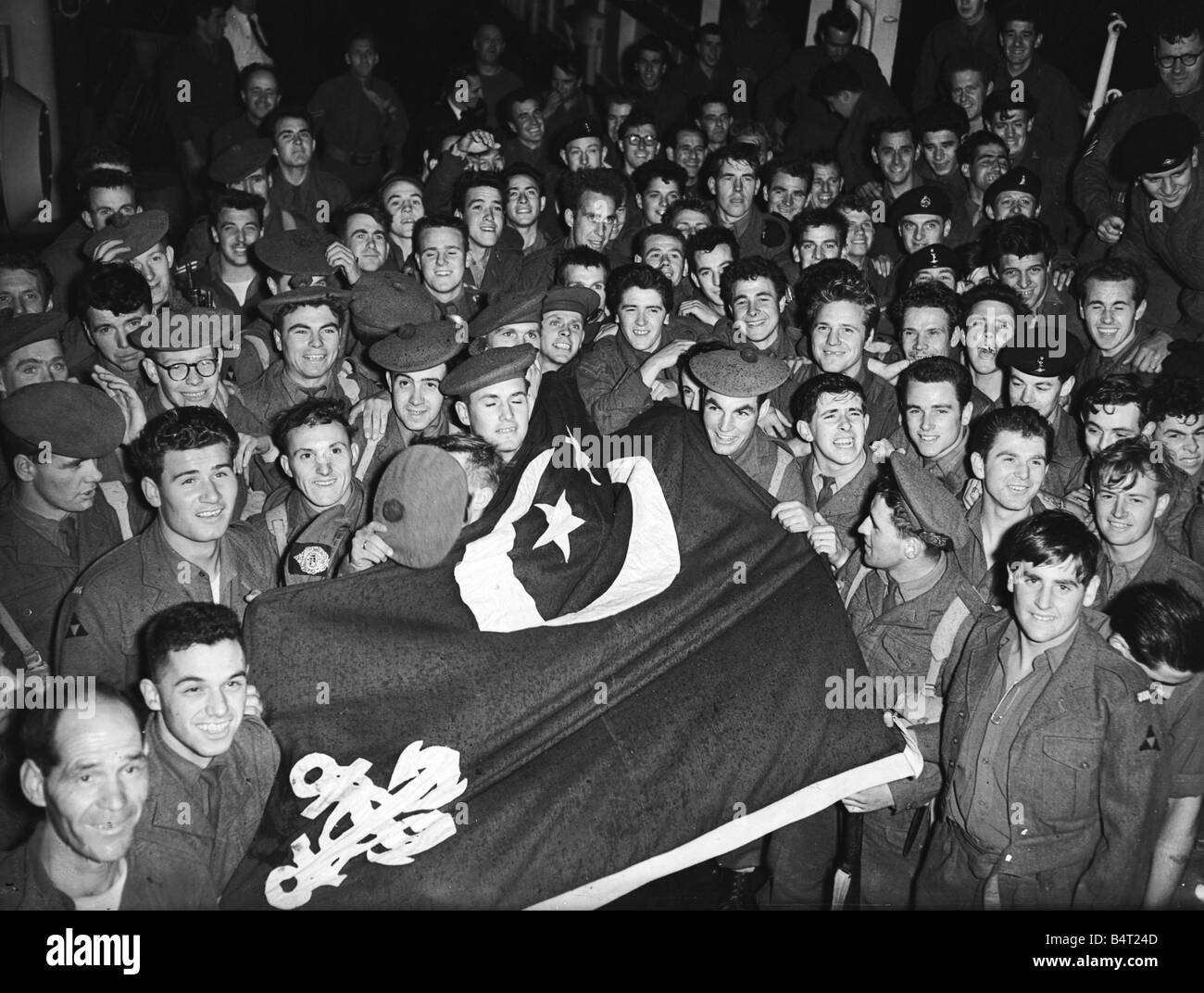 Suez Crisis 1956 Men of the first Battalion Argyle and Sutherland Highlanders display a captued Egyptian flag as they arrive back in Southampton on the troopship Asturias from Port Said Stock Photo