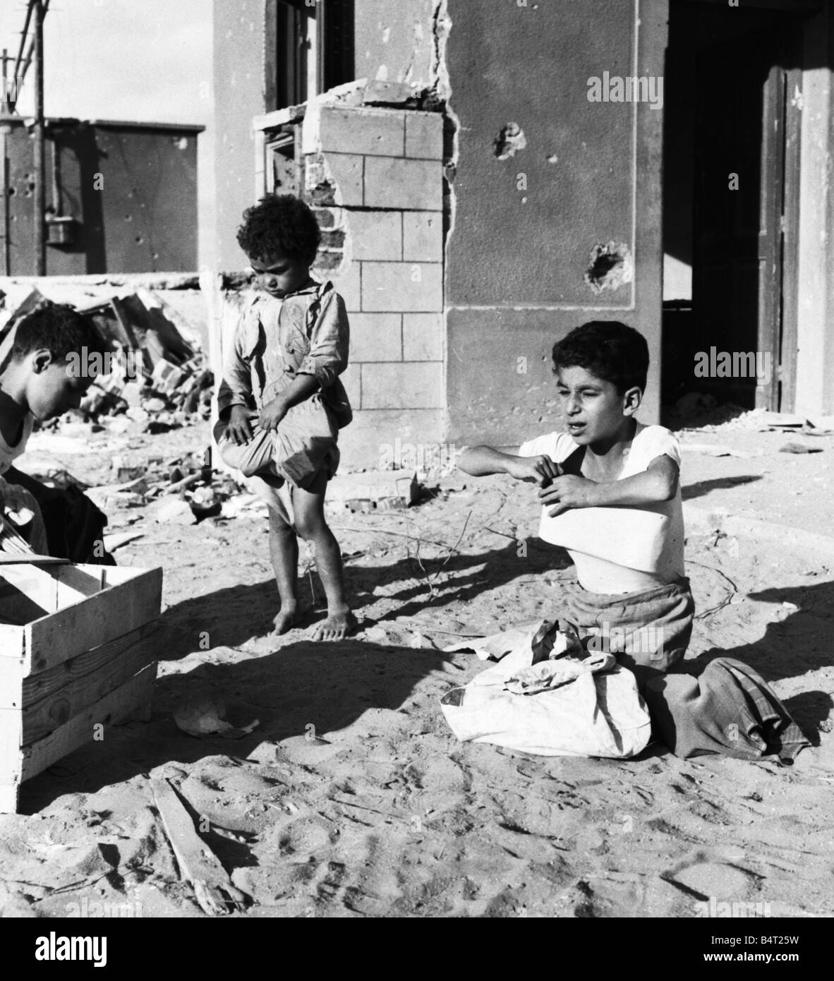 Suez Crisis 1956 Children carry off the leftovers after adults raided and looted a food store near Port Said Stock Photo