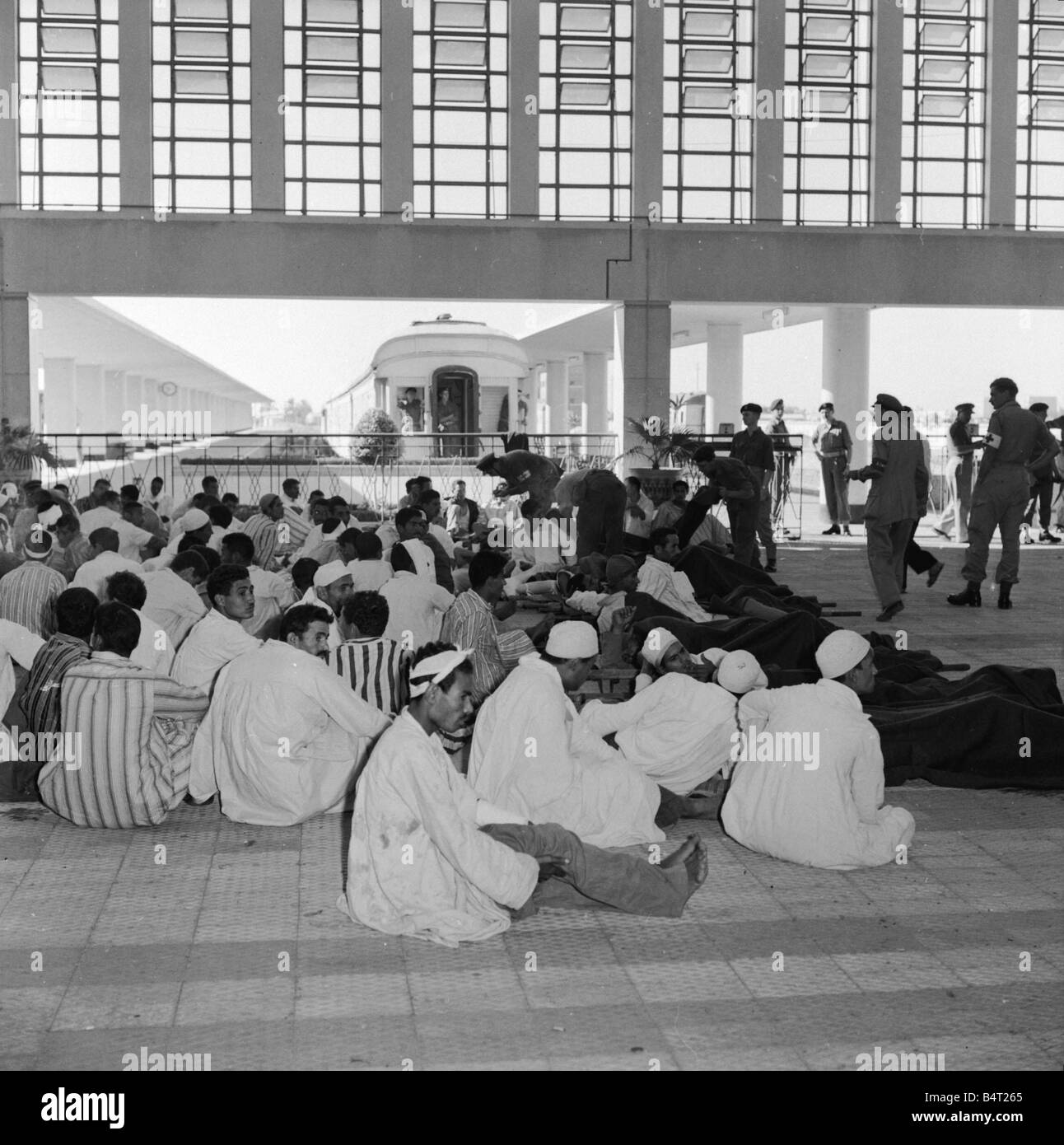 Suez Crisis 1956 Wounded Egyptian prisoners wait to be repatriated to Cairo by train as RAMC officers and their Egyptian counterparts discuss the handover Stock Photo