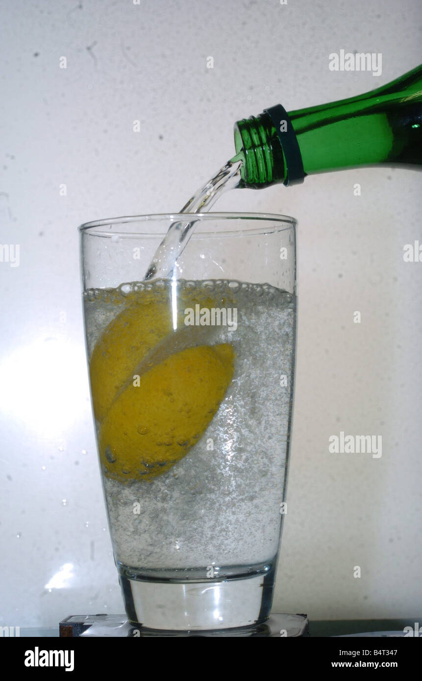 A picture of a gin and tonic drink being poured with lemon Stock Photo