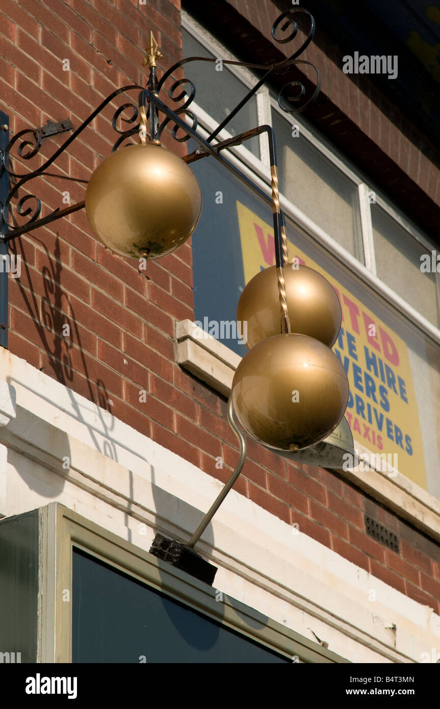 Three balls traditional pawn brokers symbol outside pawn shop Preston Lancashire England UK Stock Photo