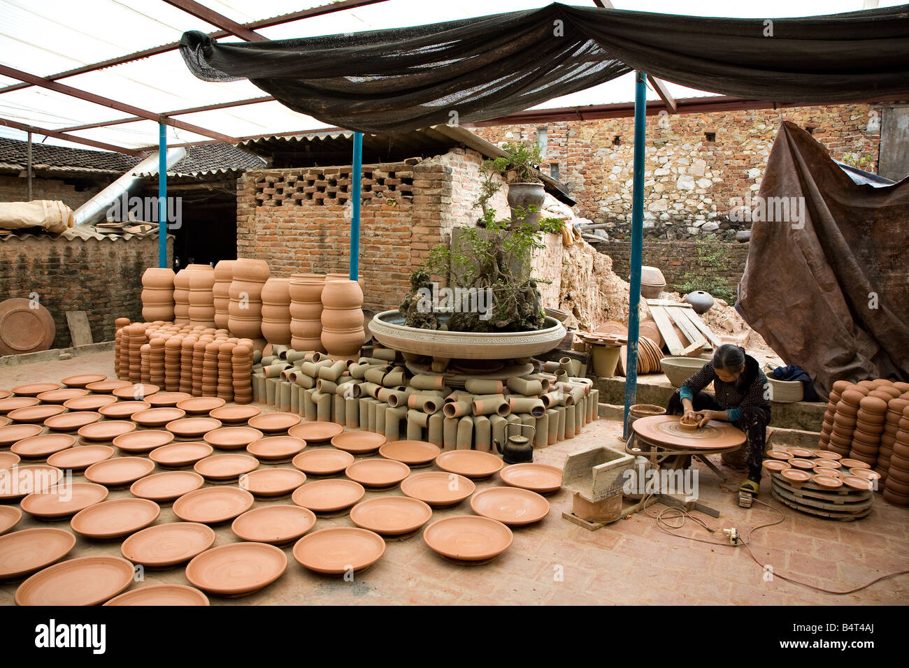 A woman working at a pottery factory Stock Photo Alamy
