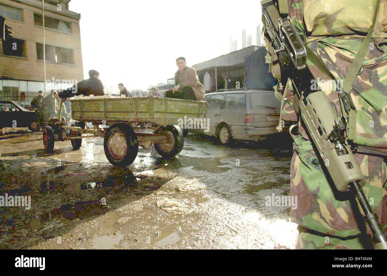 Queens Royal Hussars duty in Kosovo as apart of the KFOR peace keeping mission Traders pass into the market under the watchfull Stock Photo