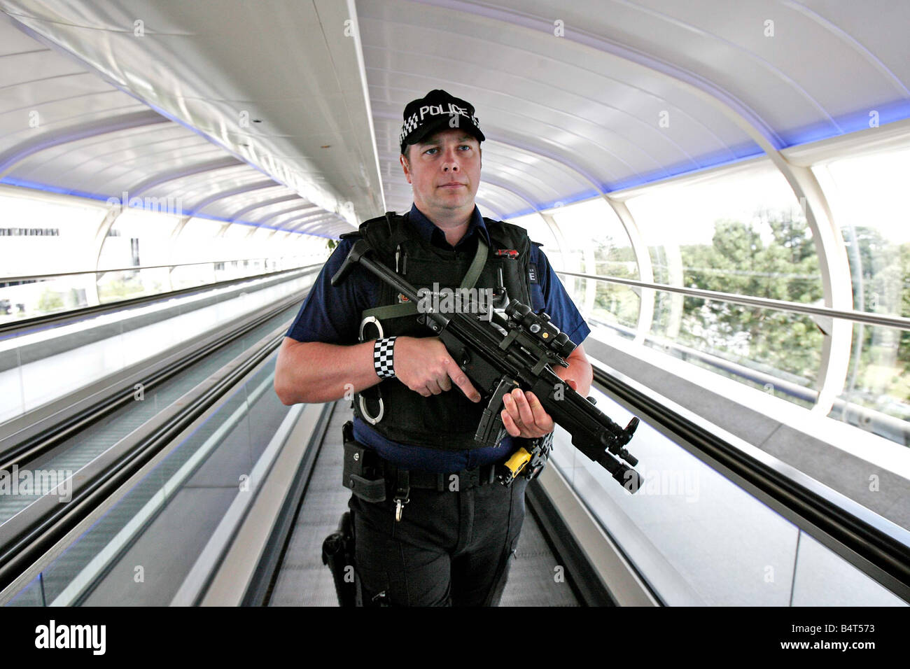 An armed police officer patrols Manchester Airport after anti terrorism units of the metropolitian police and MI5 thwarted a terrorist plot to blow up several aircraft in flight between the United States and the United Kingdom using explosives smuggled in hand luggage August 2006 Stock Photo