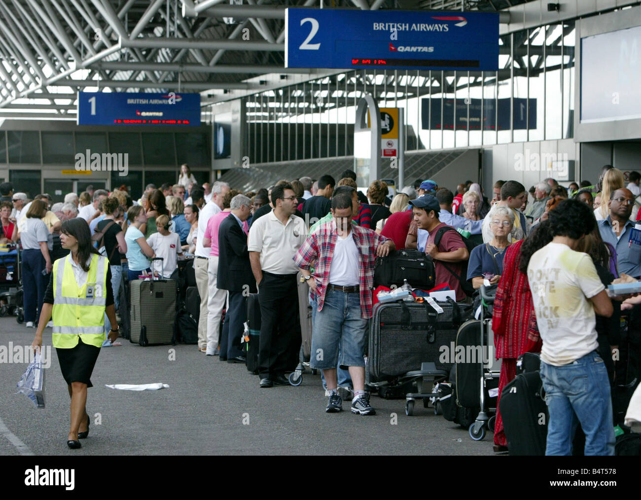 Passengers queue Terminal Four at Heathrow airport where British Airways cancelled over 40 percent of its flights after the government and airport authorities brought in tougher security measures after an aborted bomb plot August 2006 Stock Photo