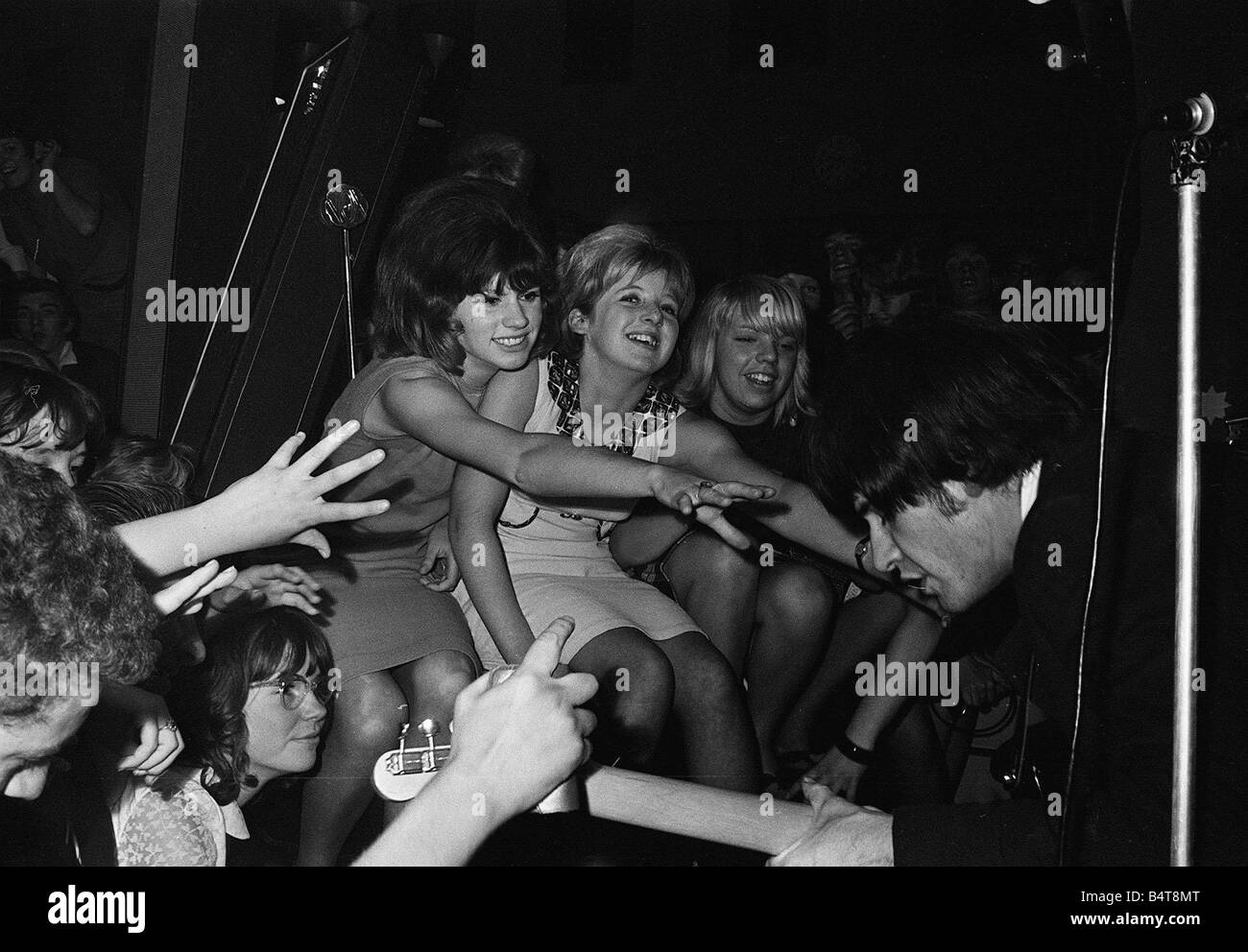 The Kinks on stage during a concert watched by adoring female fans ...