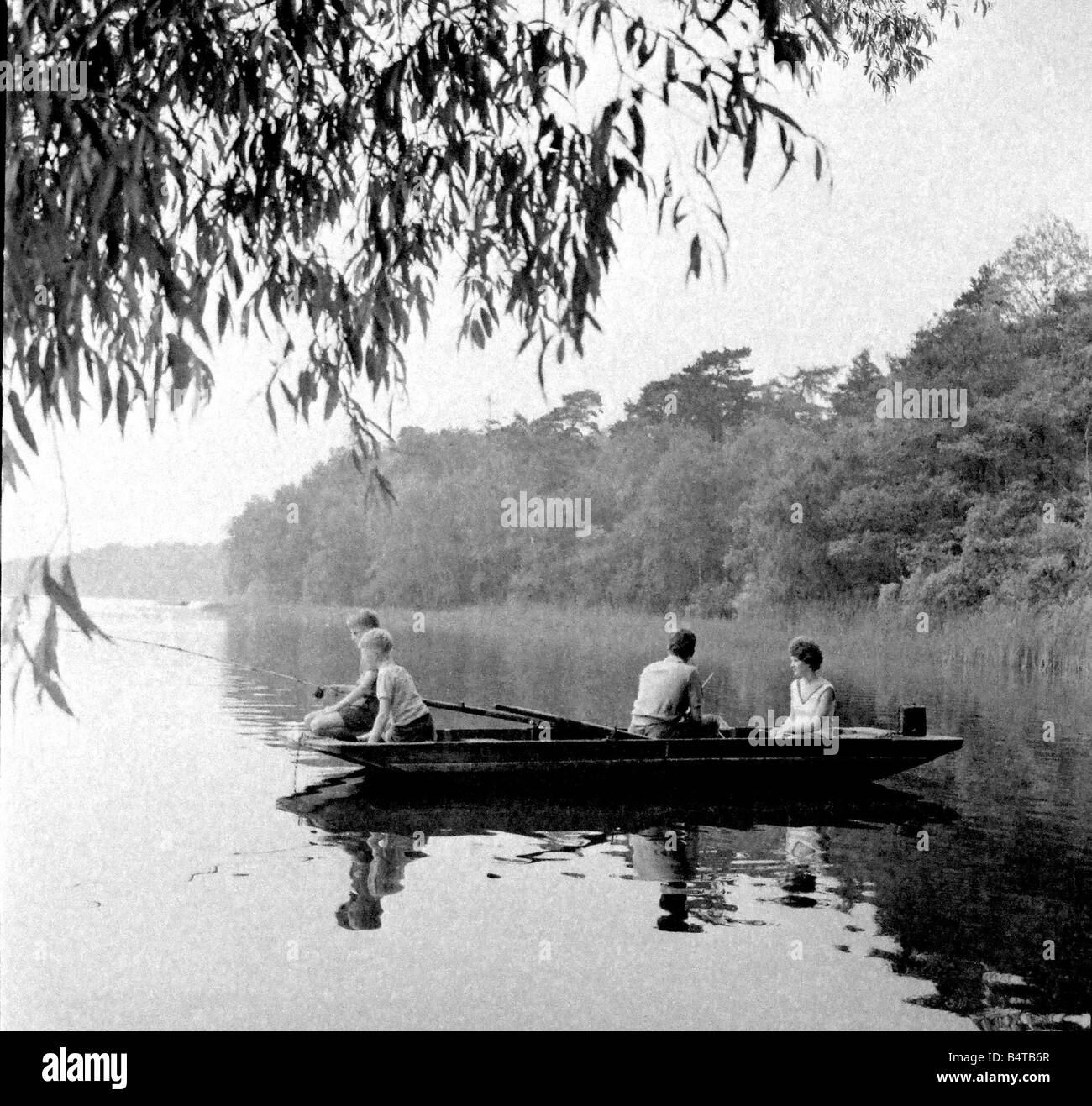 Family fishing from a boat on Bracebridge Pool on the Four Oaks side of Sutton Park Stock Photo