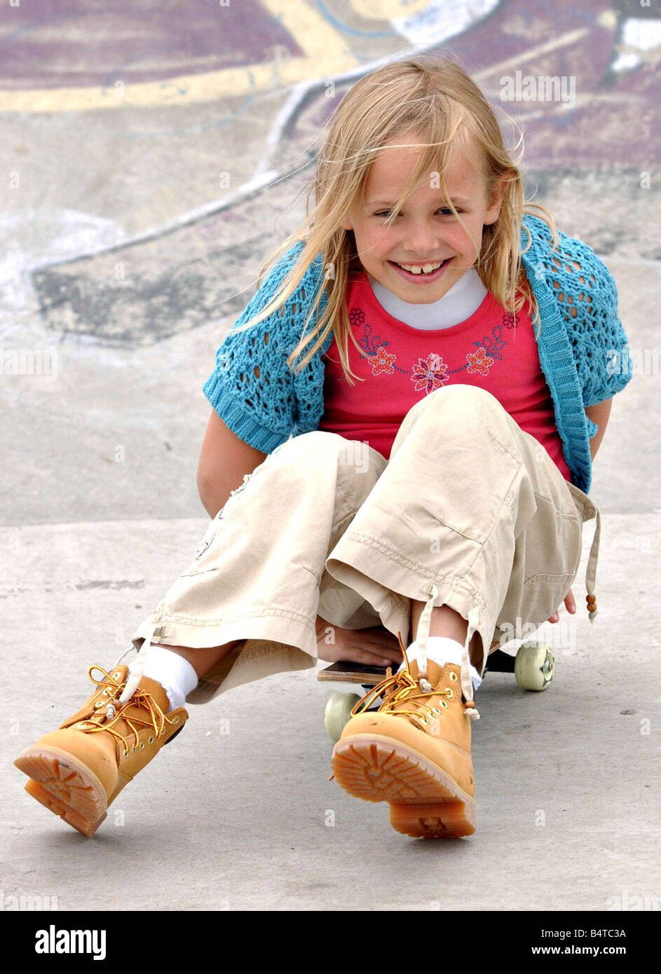 Kids skateboard fashion June 2005 model Kirsty wearing timberland boots  blue cardi pink t shirt beige trousers Stock Photo - Alamy