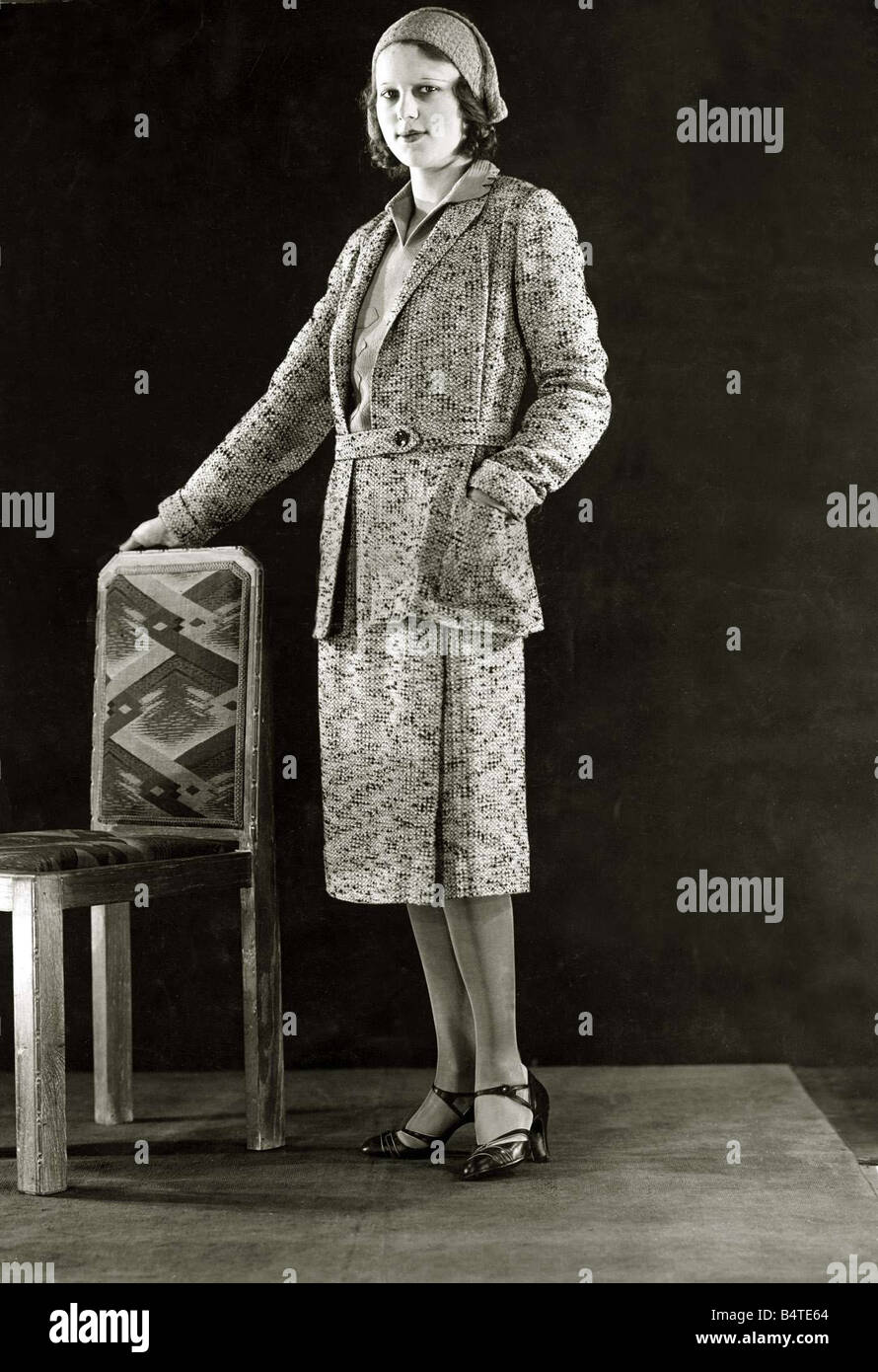 Black and Yellow flecked tweed sports suit March 1931 The jumper is of yellow stockinette The suit is worn with a chenile cap to match Mirrorpix Stock Photo