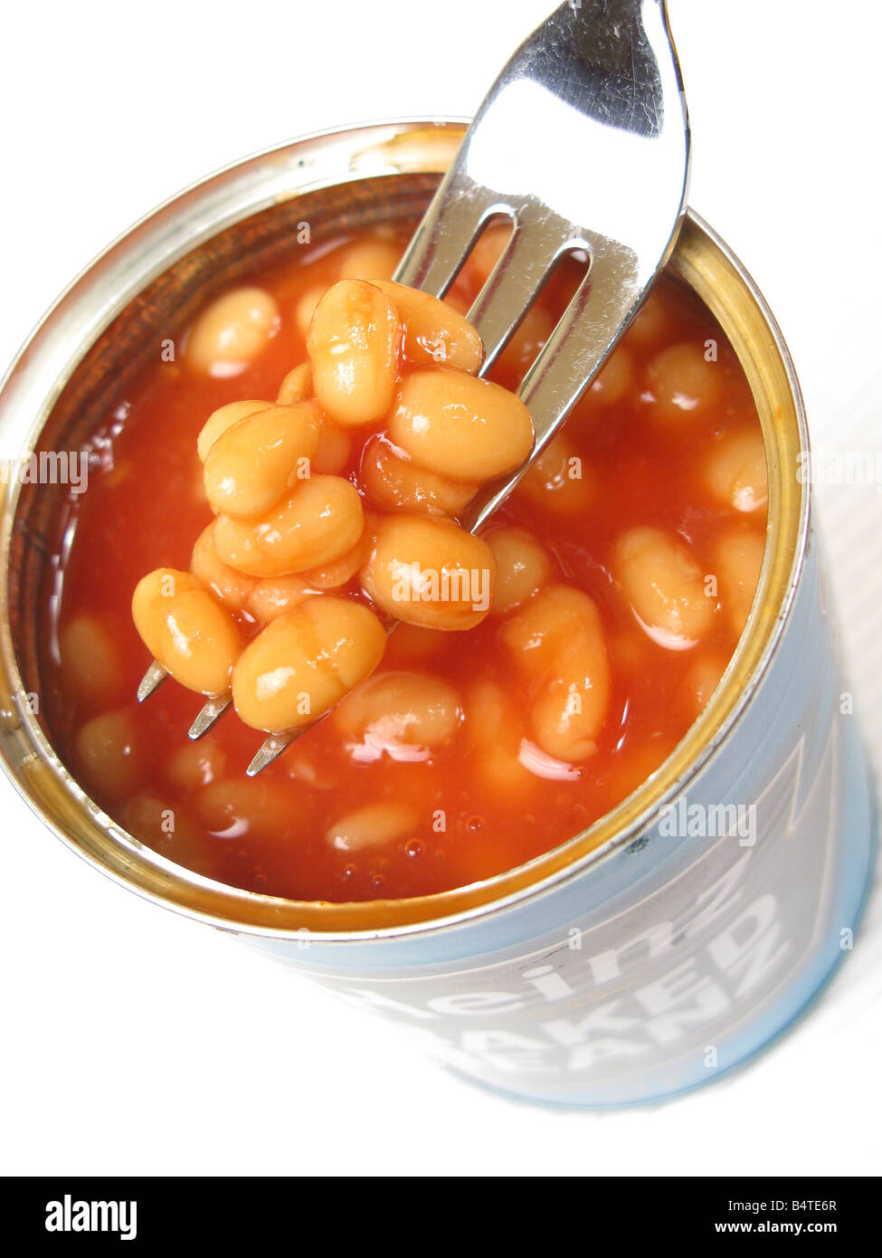 A fork removing baked beans from an open tin Stock Photo Alamy