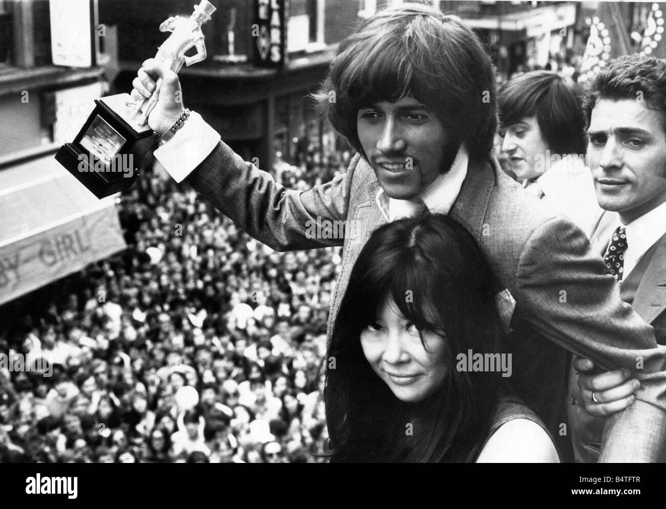 Barry Gibb holding the John Stephen statuette presented to him by Miss Tsai Chinn for being best dressed pop star of the year Stock Photo