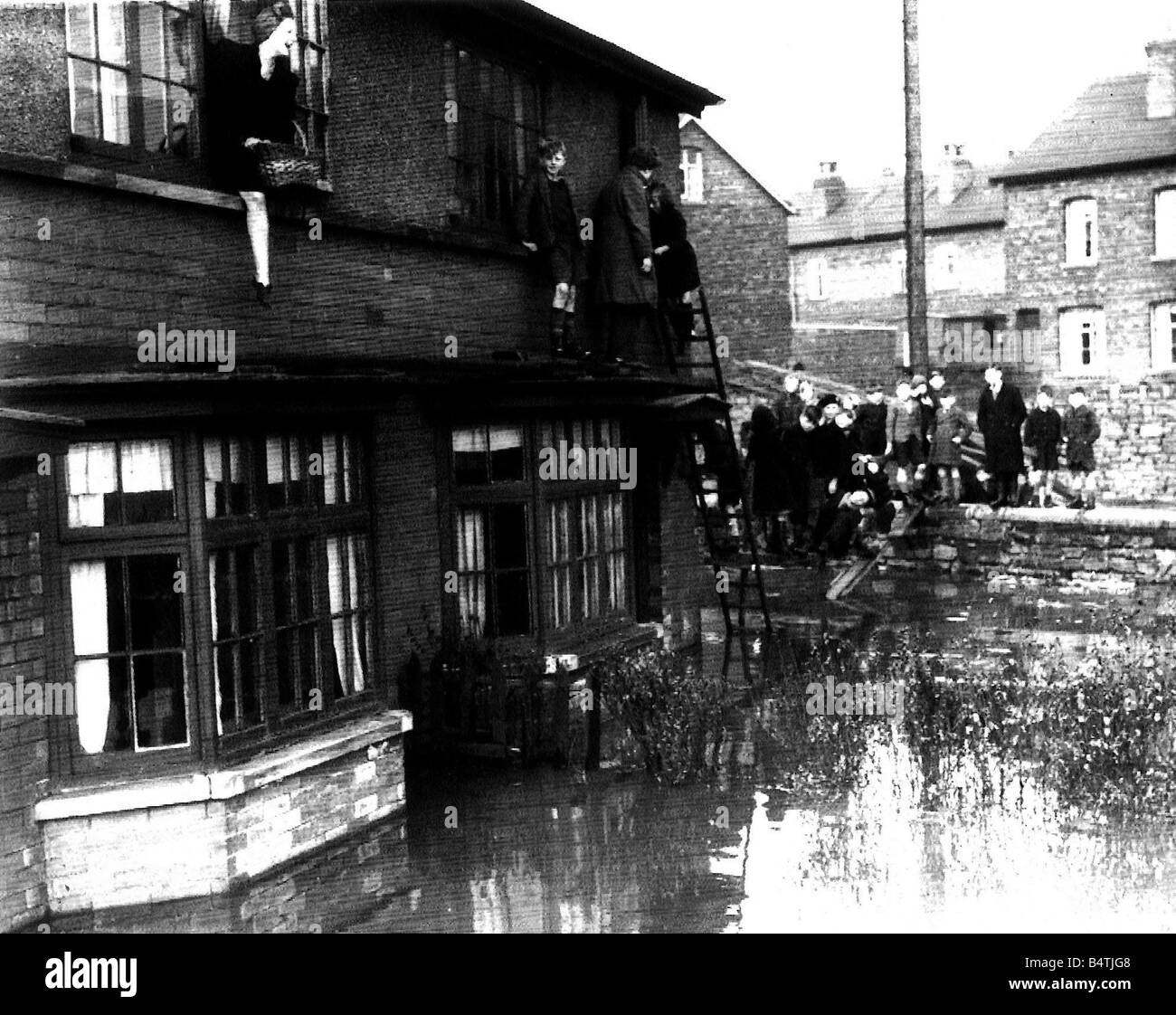 Betty Slack 17 of Orgreave Rd Catcliffe Near Rotherham S York going shopping for her mother walks the plank from the bedroom window to the garden wall before stepping onto dry land at Catcliffe Stock Photo