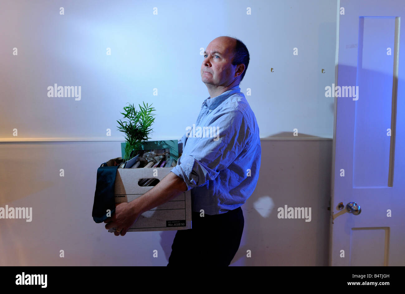 Man packs up and leaves the office after losing his job, being made redundant, being fired Stock Photo