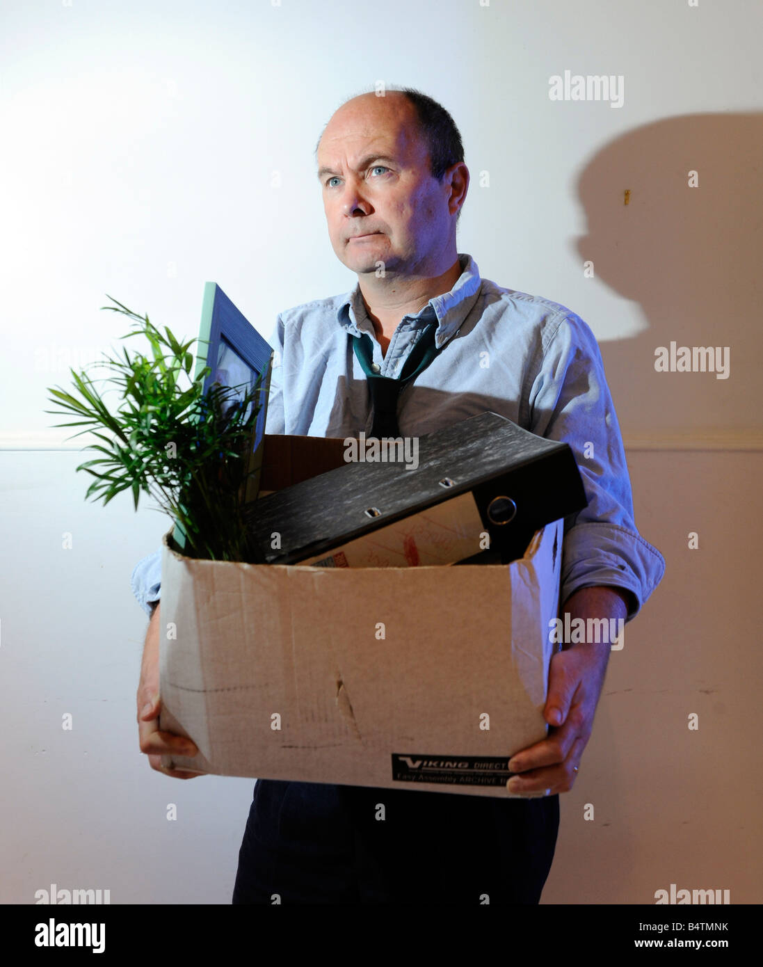 Man packs up and leaves the office after losing his job, being made redundant, being fired Stock Photo