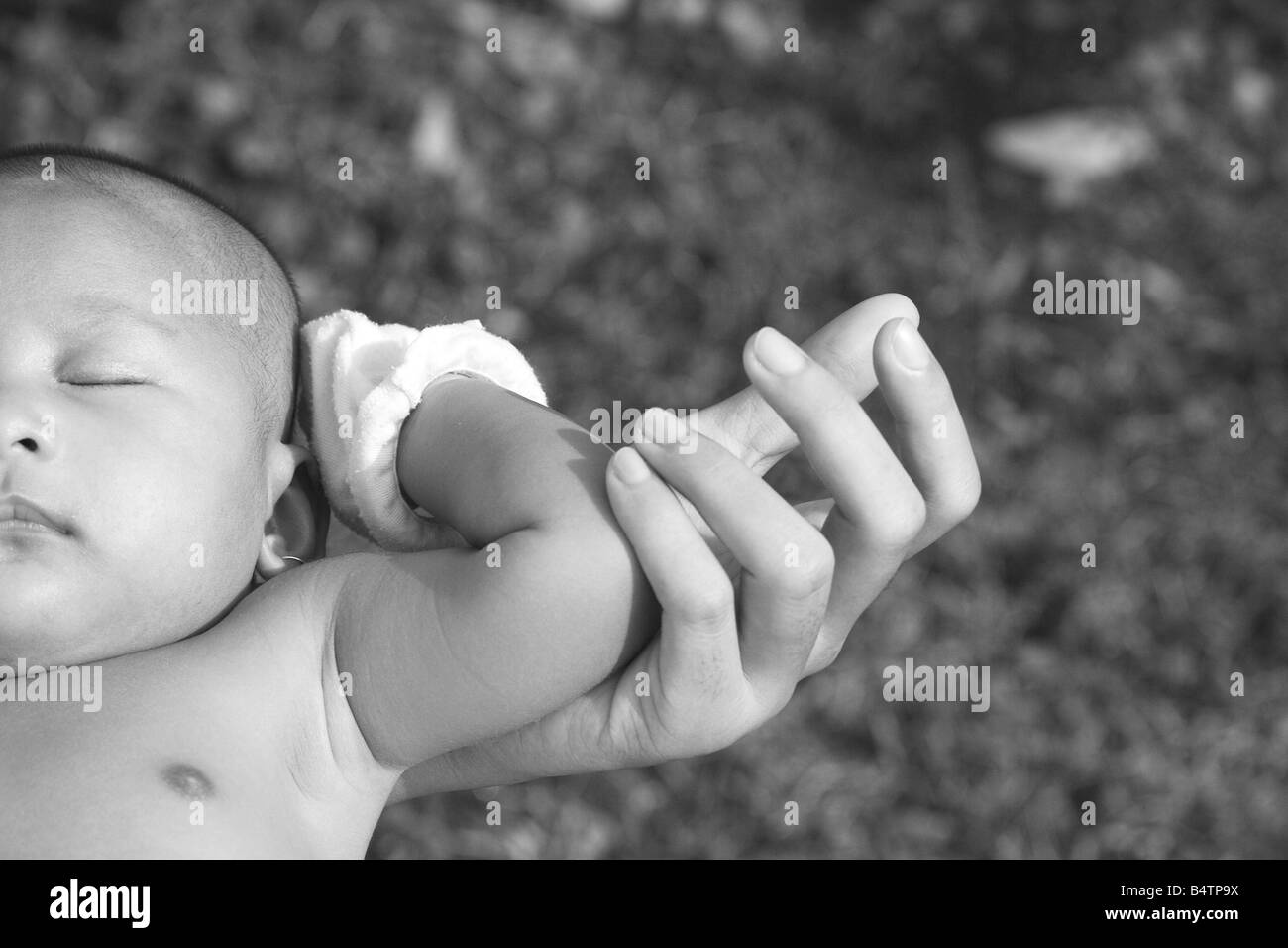 Two Months Old Asian Ethnicity Baby Sleeping On Mother's Arm During Sunbathing In The Morning Stock Photo