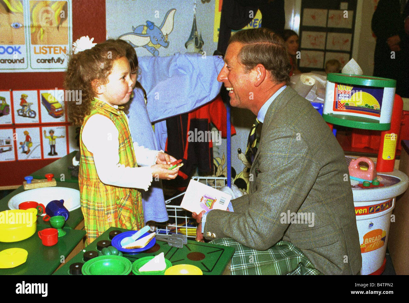 Prince Charles September 1998 HRH Prince Charles laughs with 4 yr old Savannah Knowles during his visit to the Apple Tree Nursery in Rothesay Stock Photo