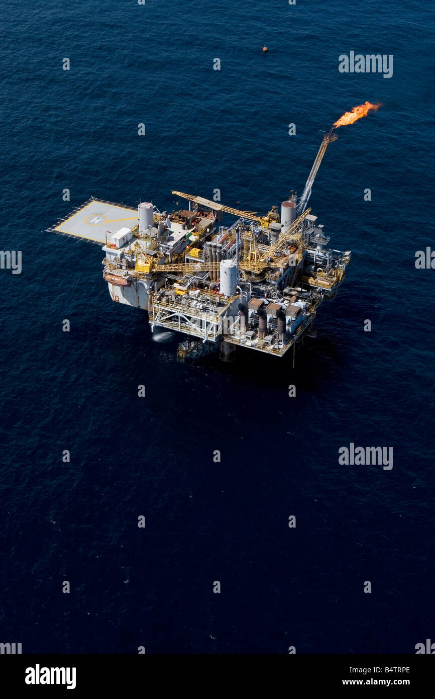 Aerial of offshore oil and gas production marine rig showing helicopter deck and safety flare off coast of Gabon Stock Photo