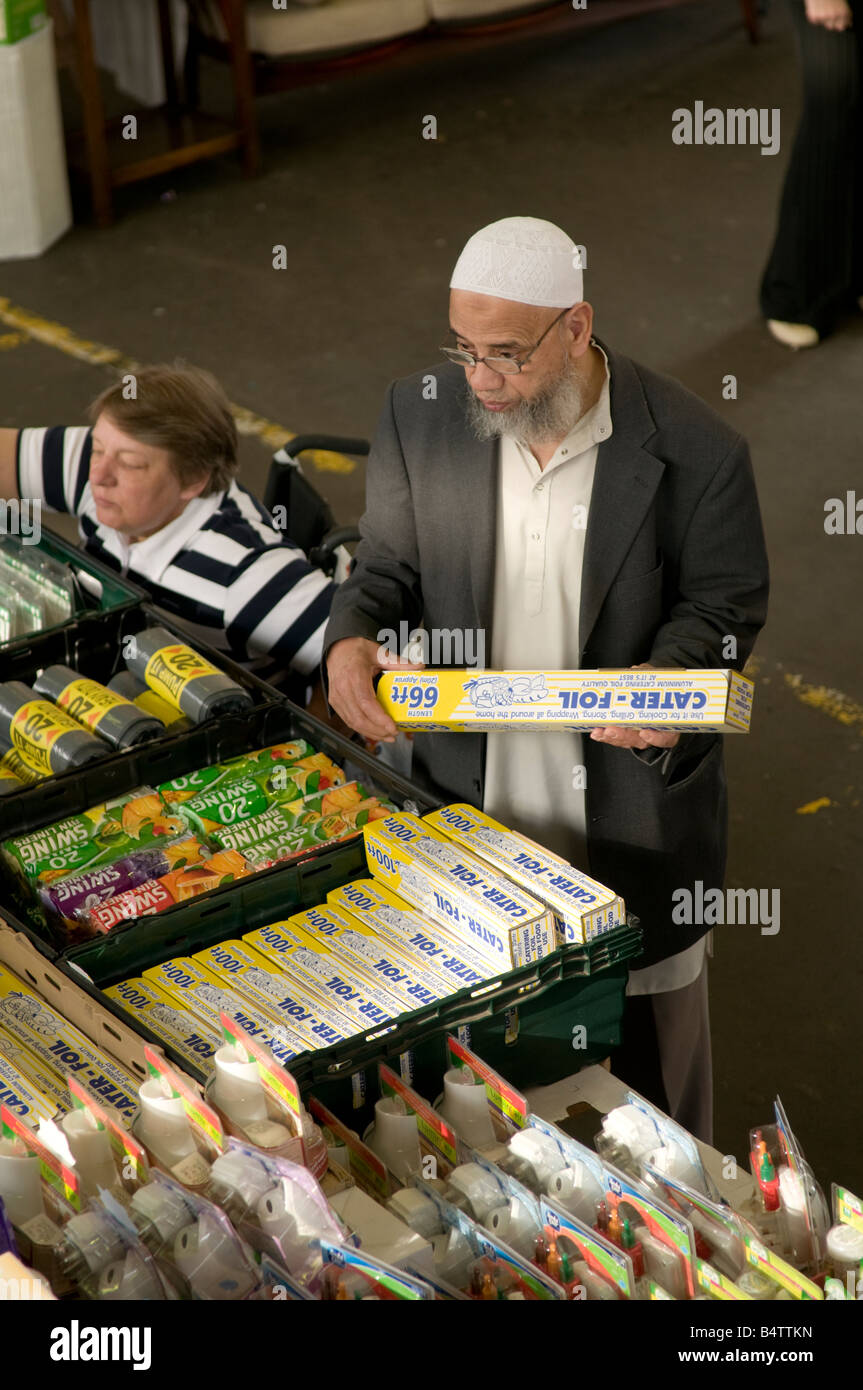 Muslim man buying roll of tin foil at Preston indoor market, Lancashire England UK Stock Photo