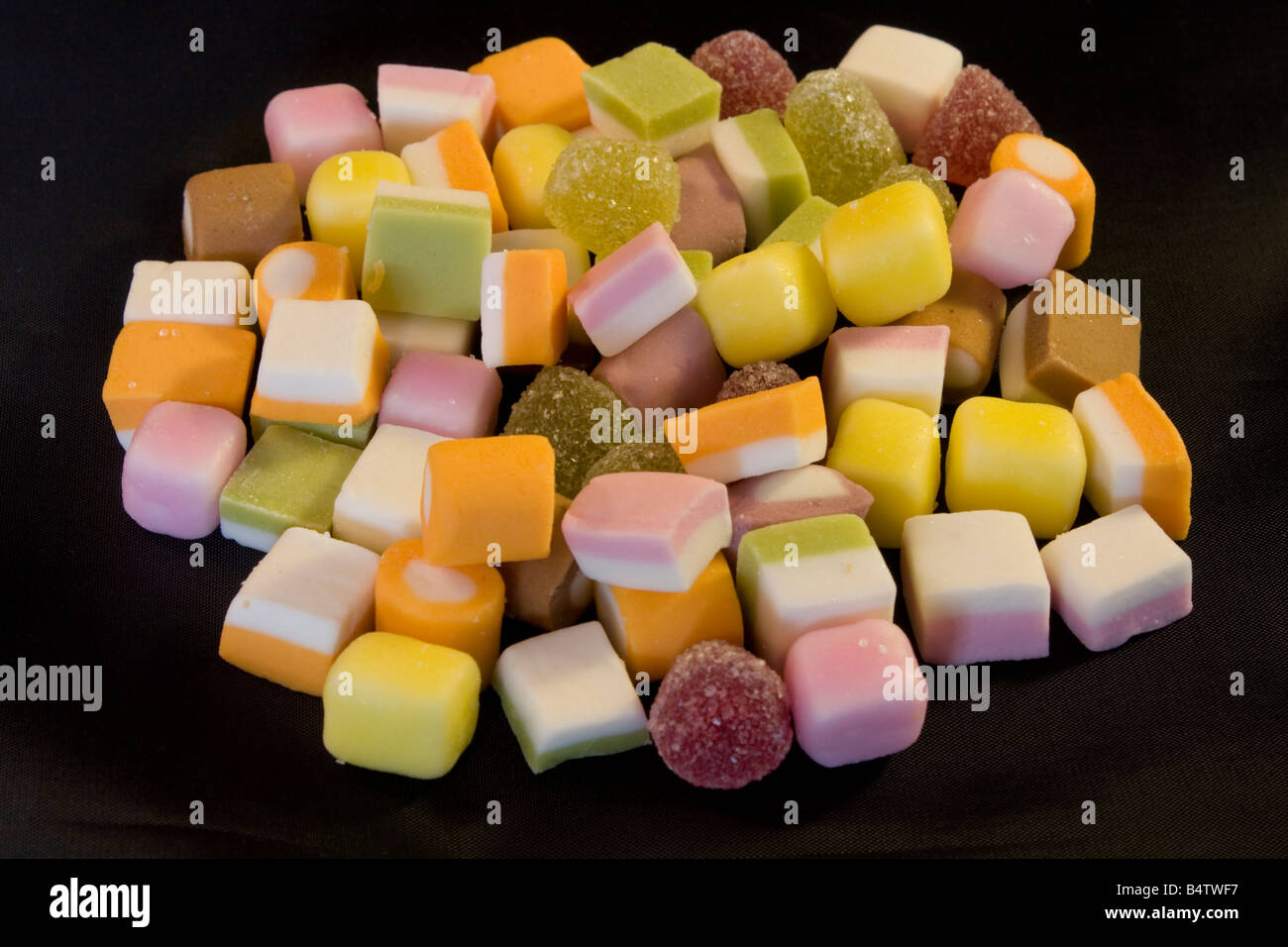 Pile of colourful dolly mixtures on black background UK Stock Photo Alamy