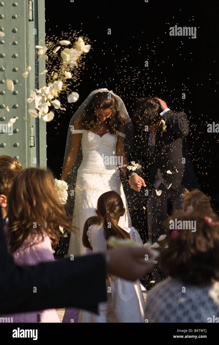 Newlyweds coming out of the church of San Miniato al Monte in Florence, Italy under a shower of rice, flowers and confetti. Stock Photo