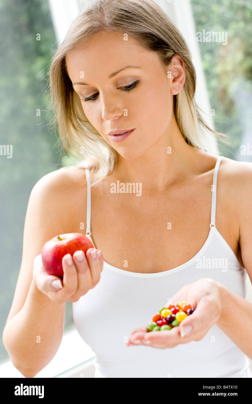 Girl making choice between healthy/unhealthy food Stock Photo