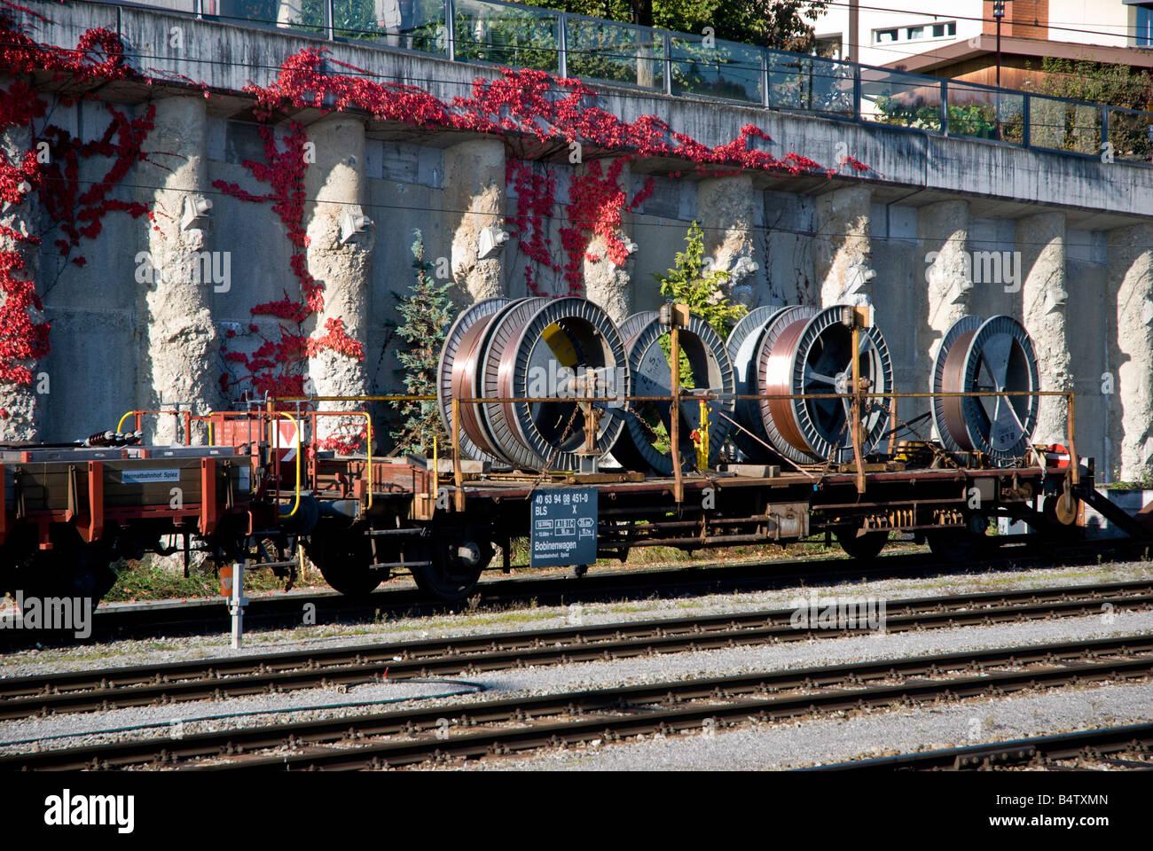 A flatbed railroad with a load of copper cable sits on a sidetrack
