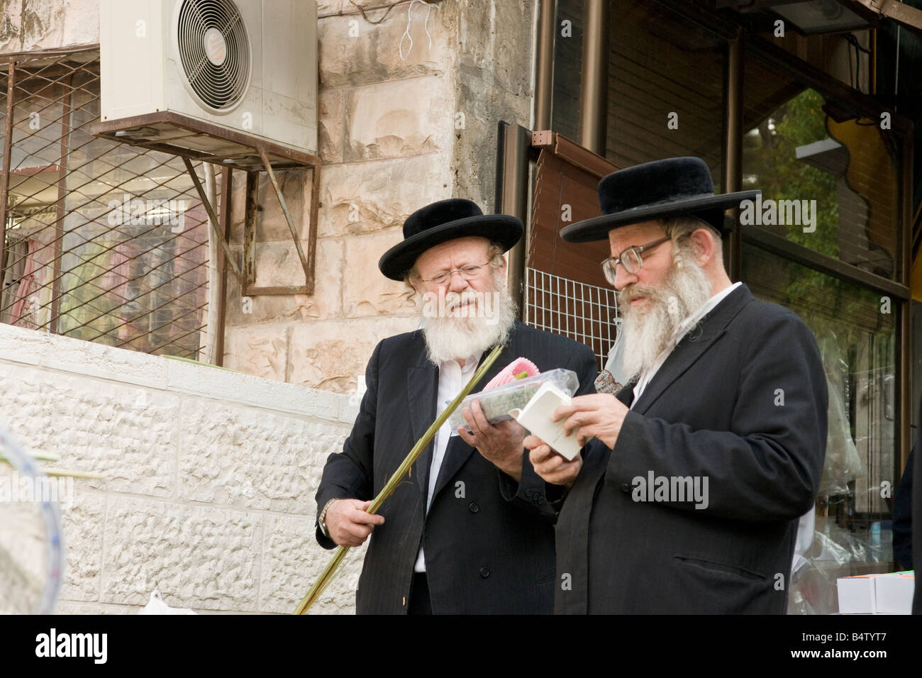 Two Orthodox Jews, holding 'the four species',  which are part of the rituals during the Jewish holiday of Sukot. Stock Photo