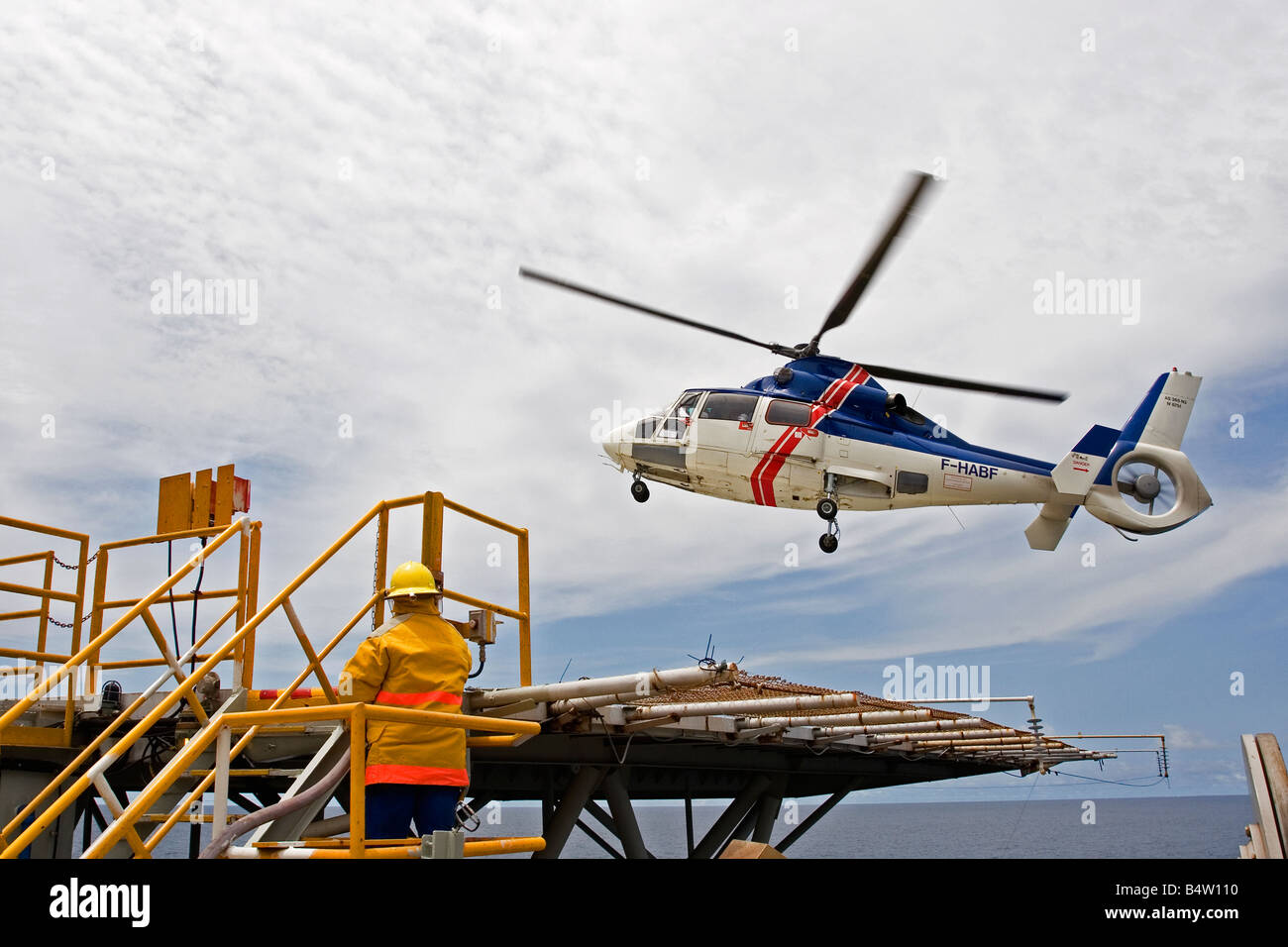Helicopter landing on offshore marine production oil rig with crew change of oil workers, off coast of Gabon, Western Africa Stock Photo