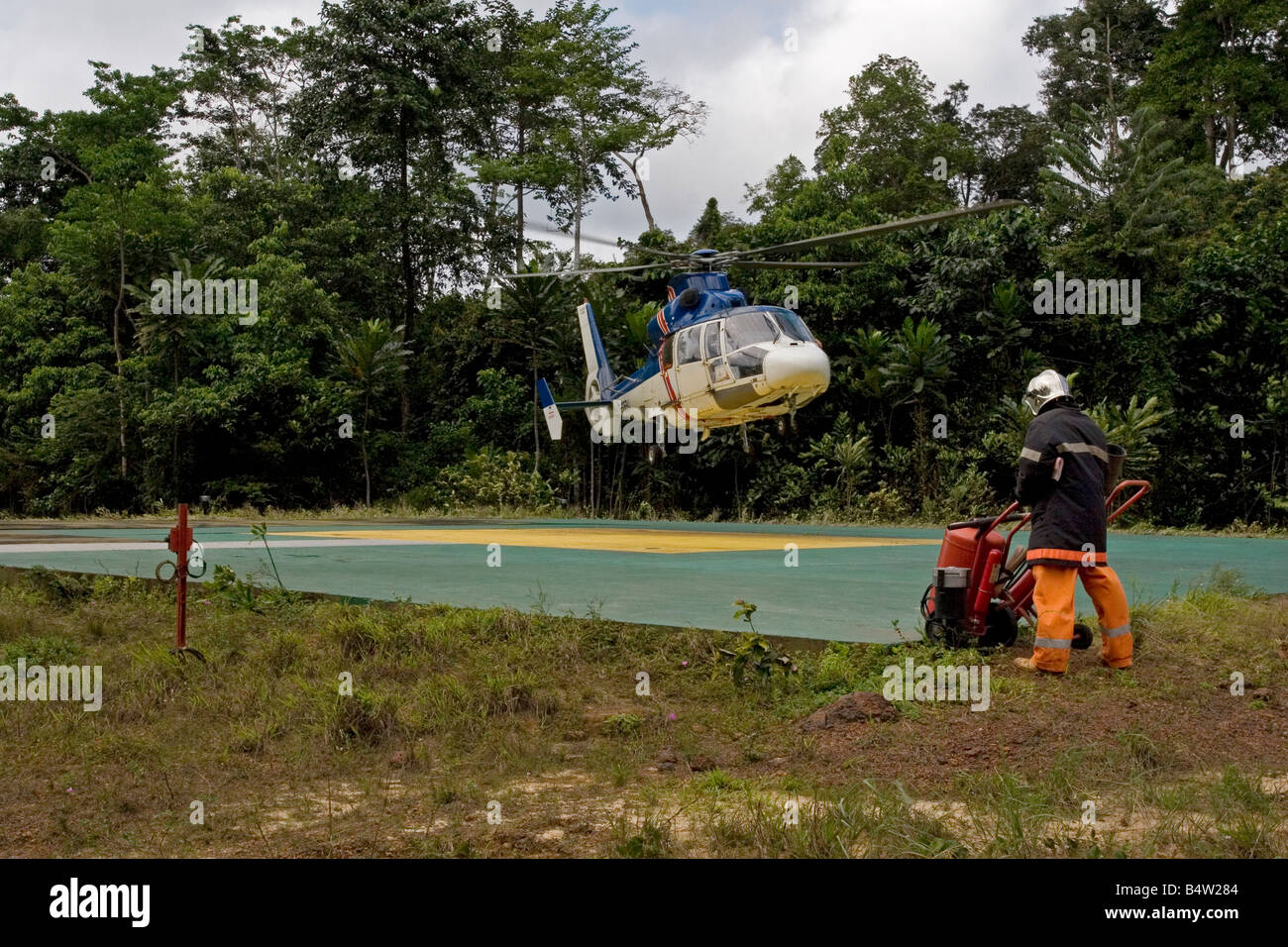 Helicopter landing at remote jungle onshore oil site in rainforest with oil workers, Gabon, Western Africa Stock Photo
