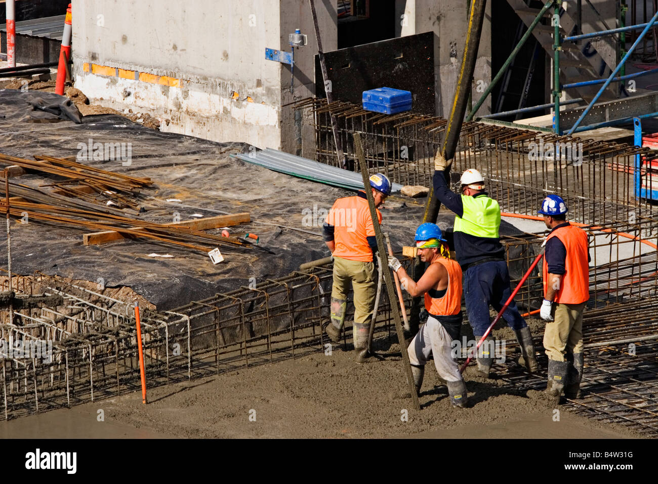 Construction / Construction workers pour cement on a building Stock
