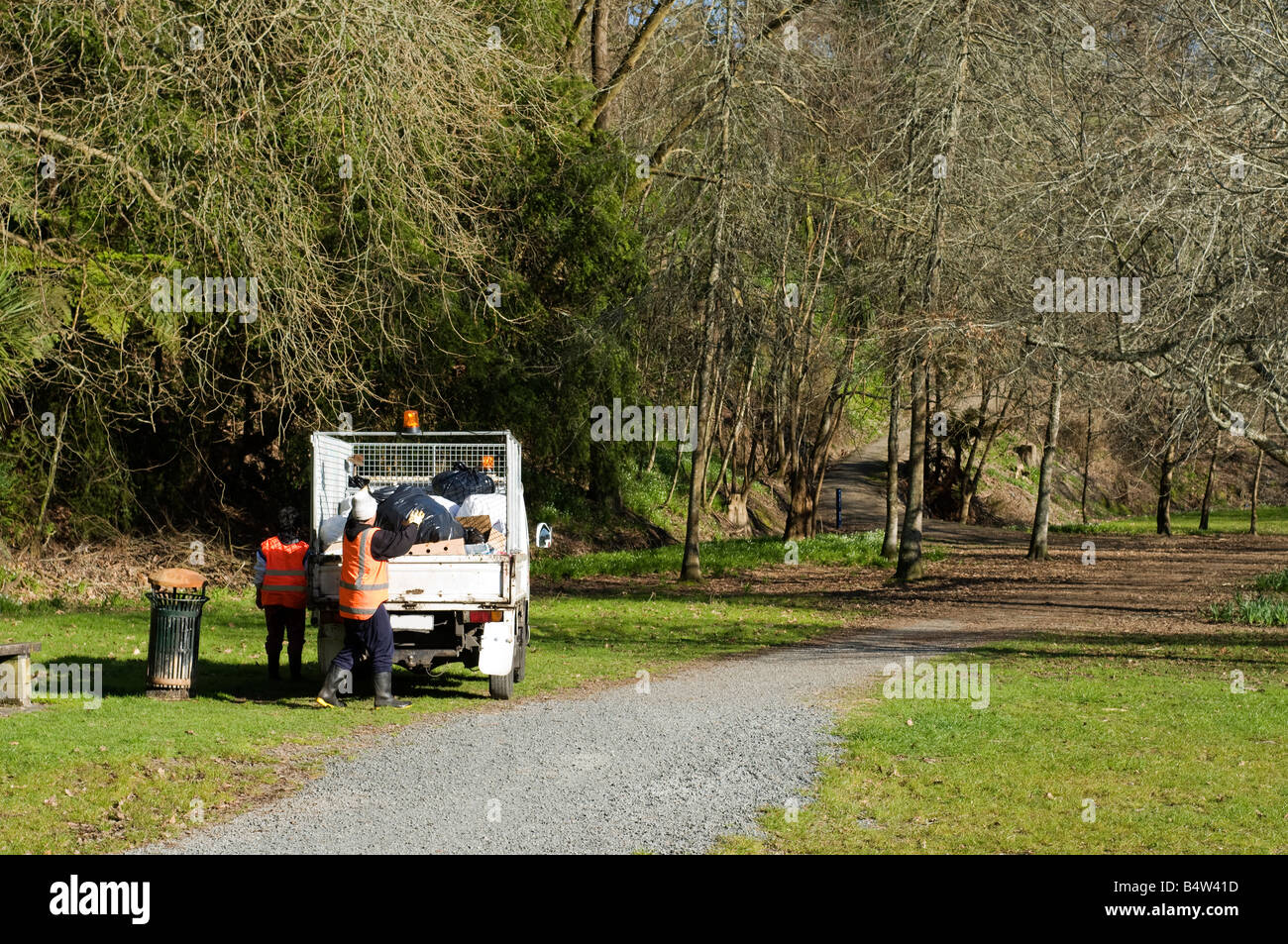 two adults emptying rubbish bins into van, new Zealand, Cambridge Stock