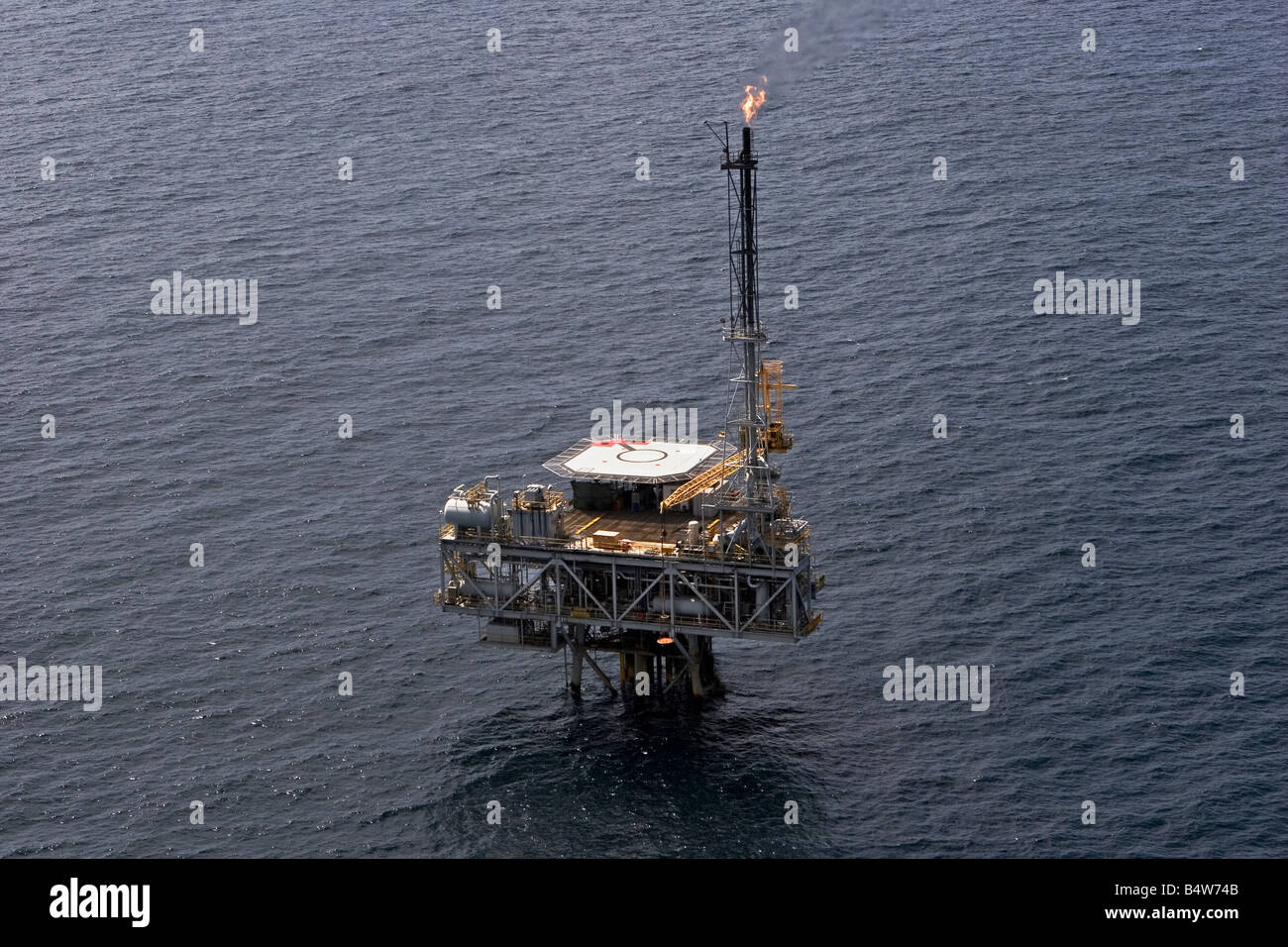 Aerial of remotely operated offshore oil and gas production marine rig showing safety flare off coast of Gabon Stock Photo