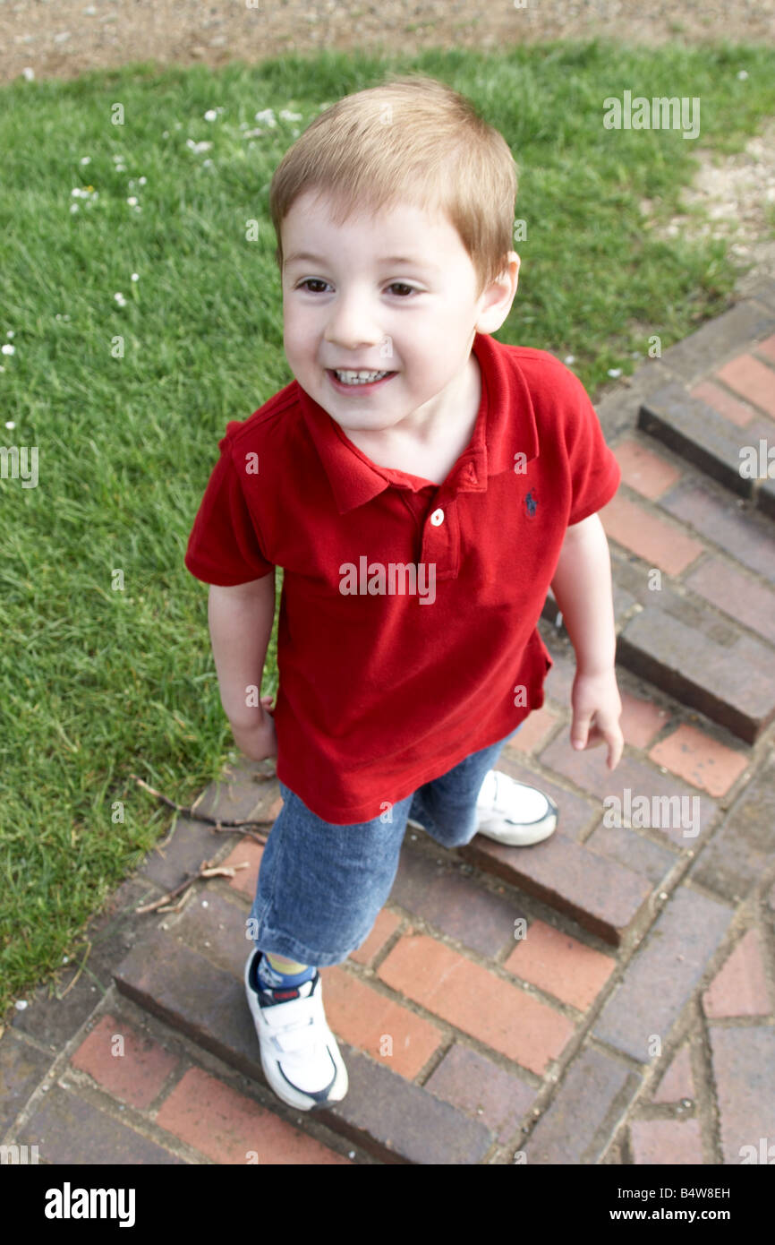 Young boy child with red shirt outdoors looking up smiling CJWH Stock