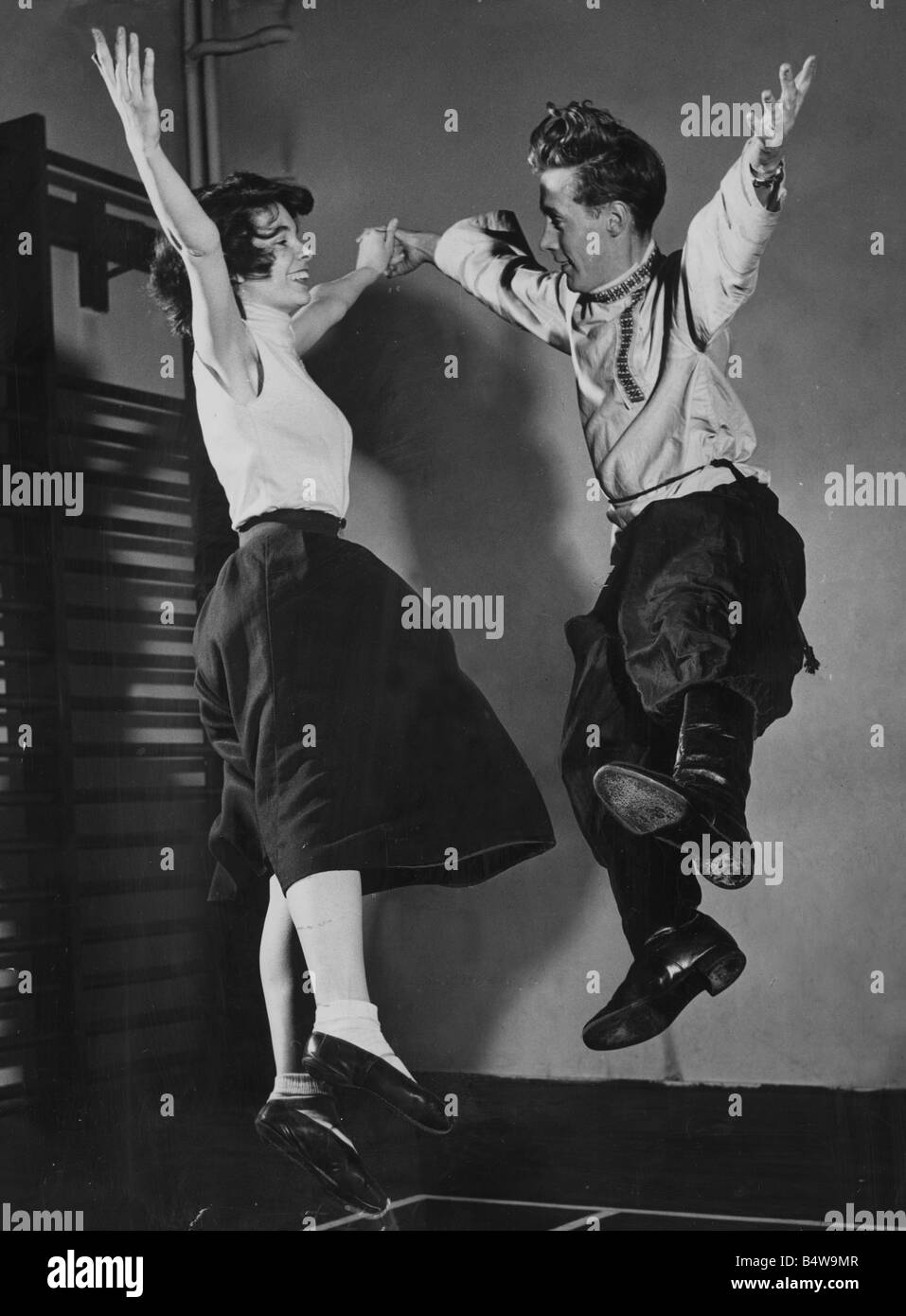 A couple performing a traditional Russian folk dance during a rehearsal of Olk Dancing at the carlyle School in Chelsea where they are preparing to give a festival of dances at the Albert Hall April 1953 Mirrorpix couple dancing men women 1950s humour clothing Stock Photo