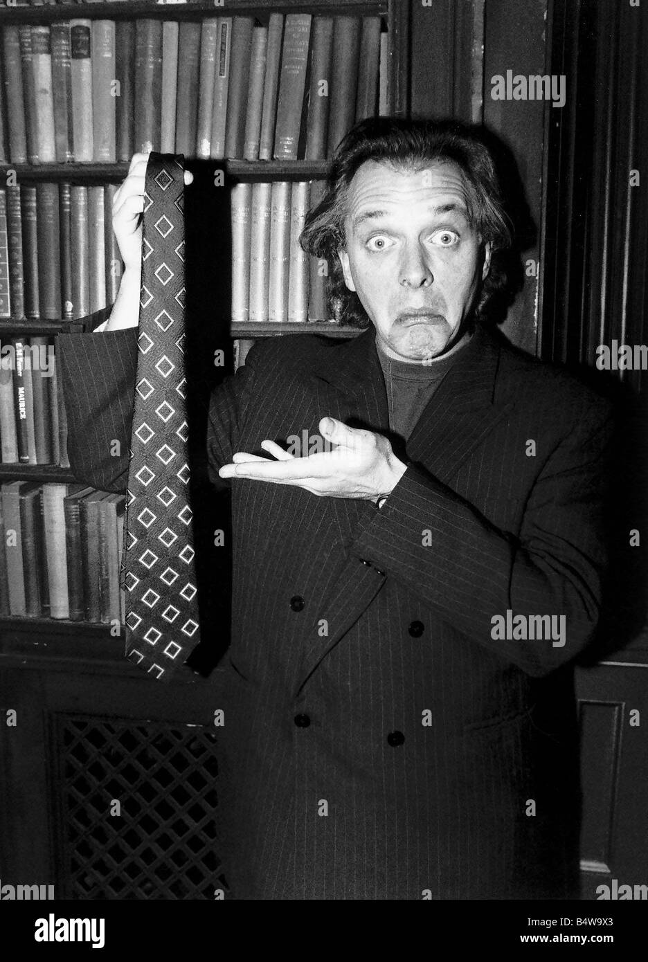 Rik Mayall holding up a tie Making a funny face January 1989 Stock Photo