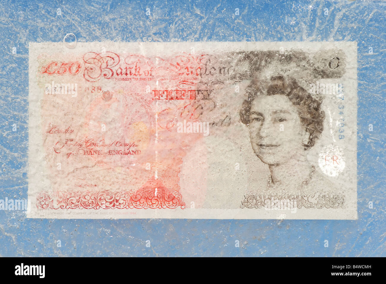 Fifty pound note frozen in ice Stock Photo