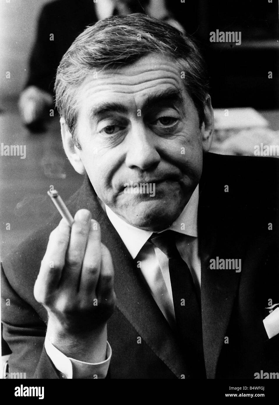 Tony Hancock holding up a lit cigarette August 1966 Stock Photo