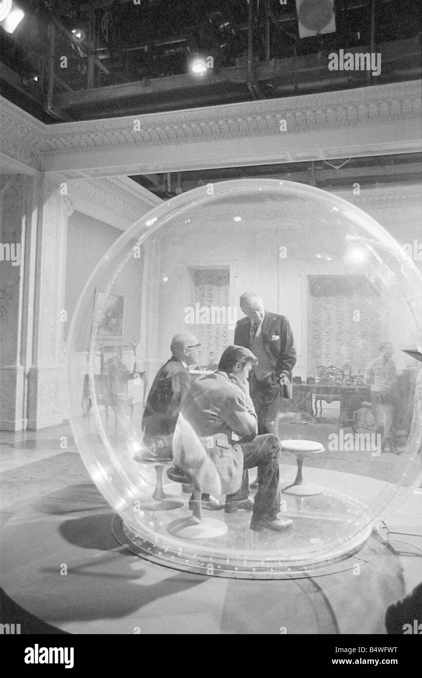 Left to Right Lionel Jeffries Laurence Harvey and Eric Portman seen here on the set of The spy with a cold nose at Shepperton Studios The actors are seen here in The dome an anti bugging device constructed of perspex and 9 foot in diameter In the film the three actors get locked inside the device July 1966 W7237 Stock Photo