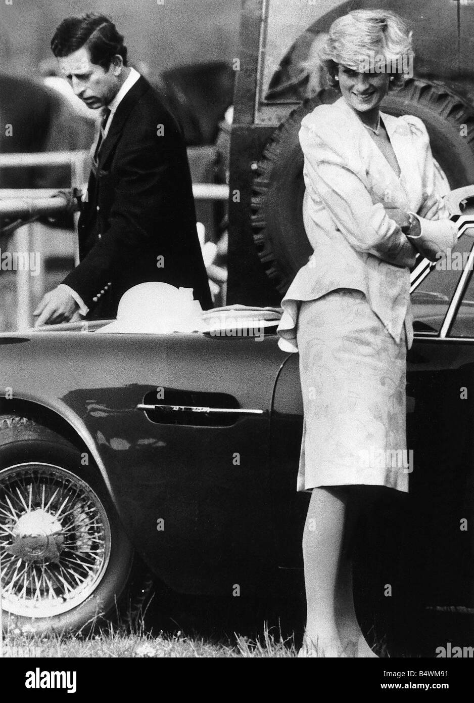 Prince Charles is examining the bodywork of his Jreg Aston Martin which