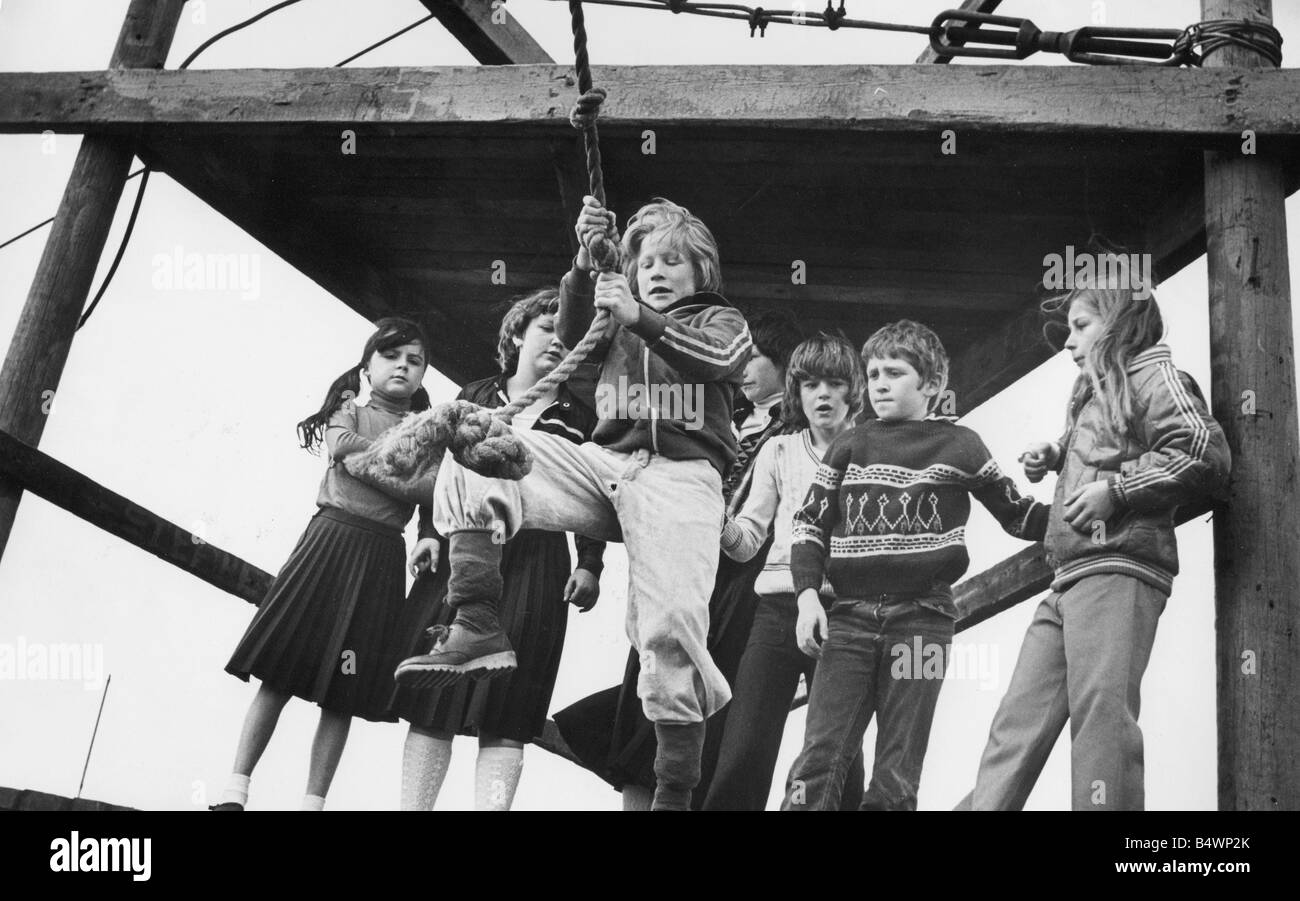 Children enjoy an adventure playground rope swing Stock Photo Alamy