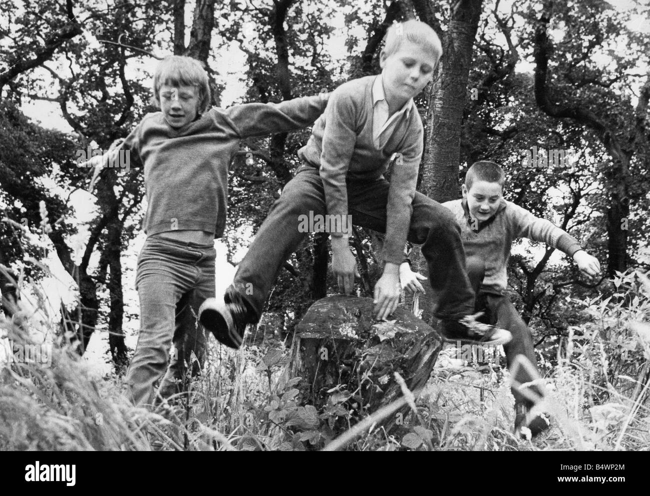 Children enjoy a day out in the woods playing leapfrog Stock Photo