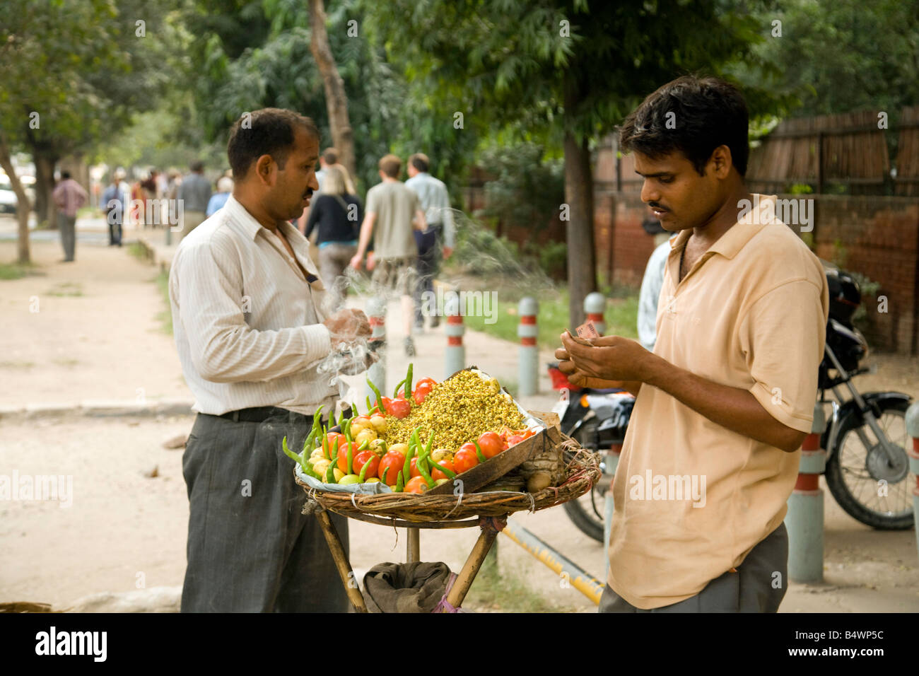 A street trader selling vegetables to a passer by, New Delhi, India Stock Photo