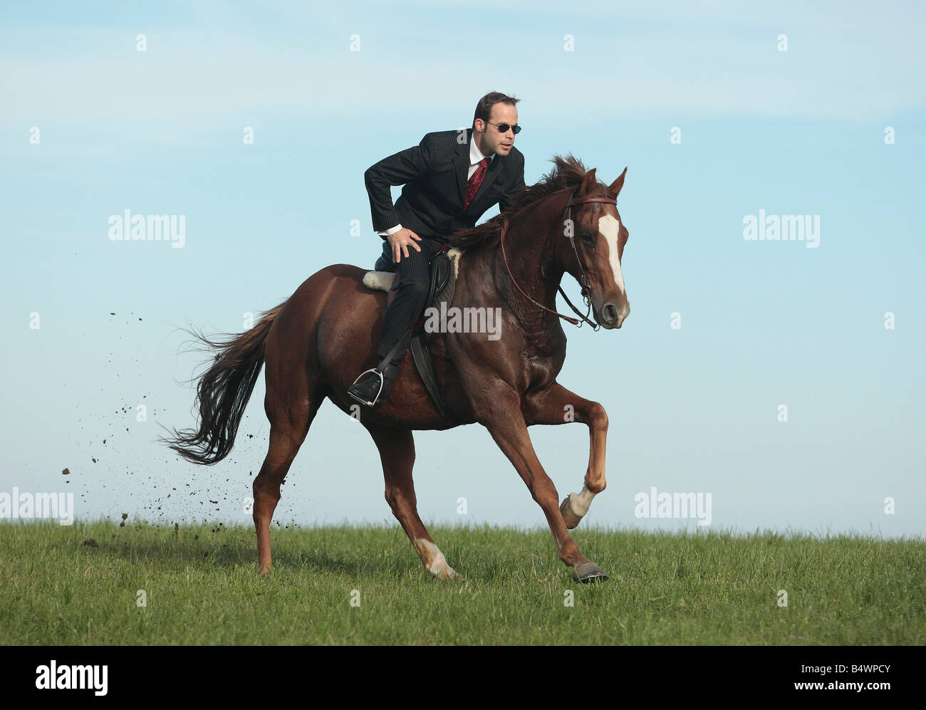 Young businessman riding a horse at full gallop Stock Photo
