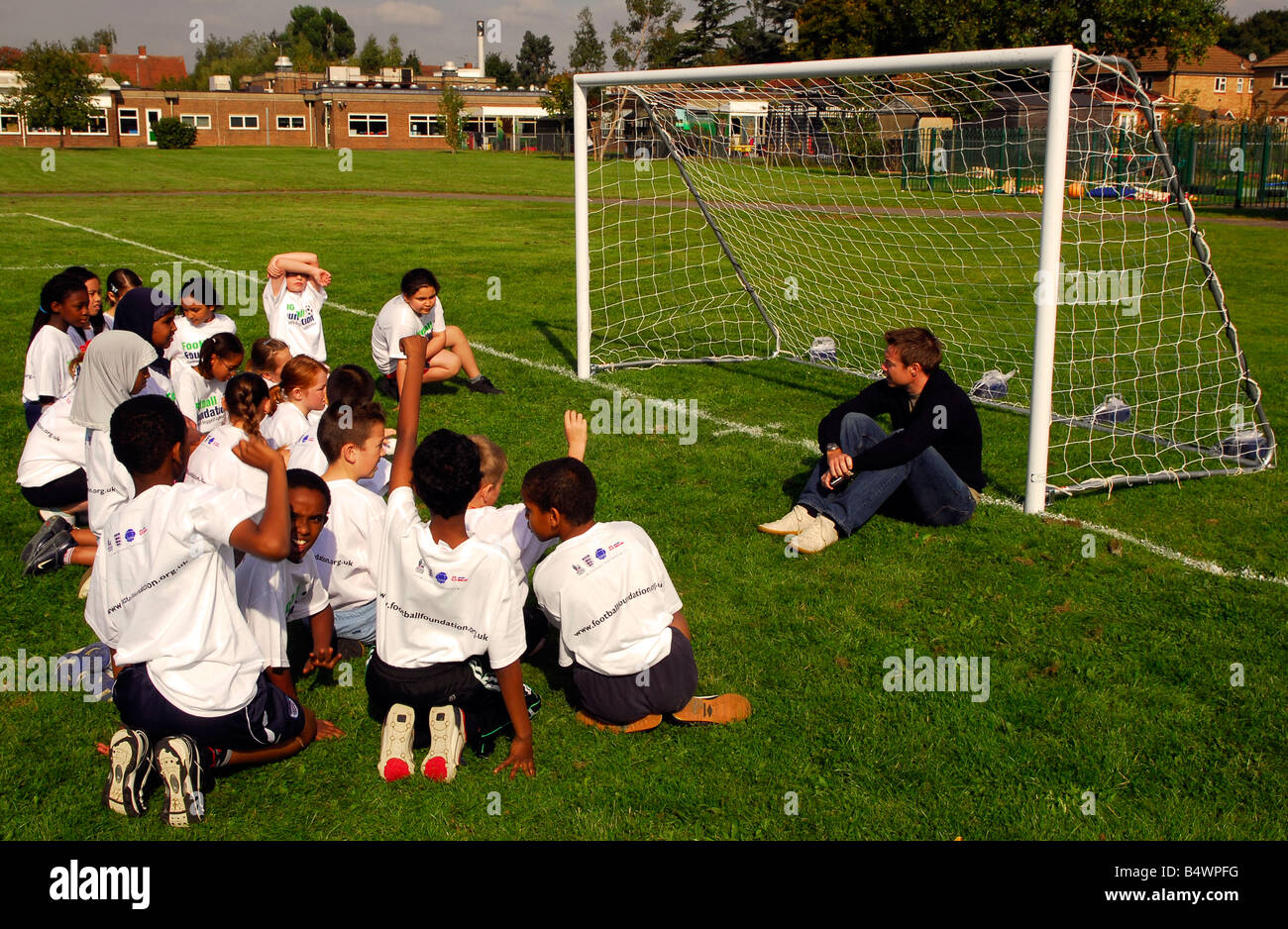 Ex Chelsea and England footballer Graeme Le Saux with primary school kids at opening of new football pitch, Hounslow, Middx, UK. Stock Photo